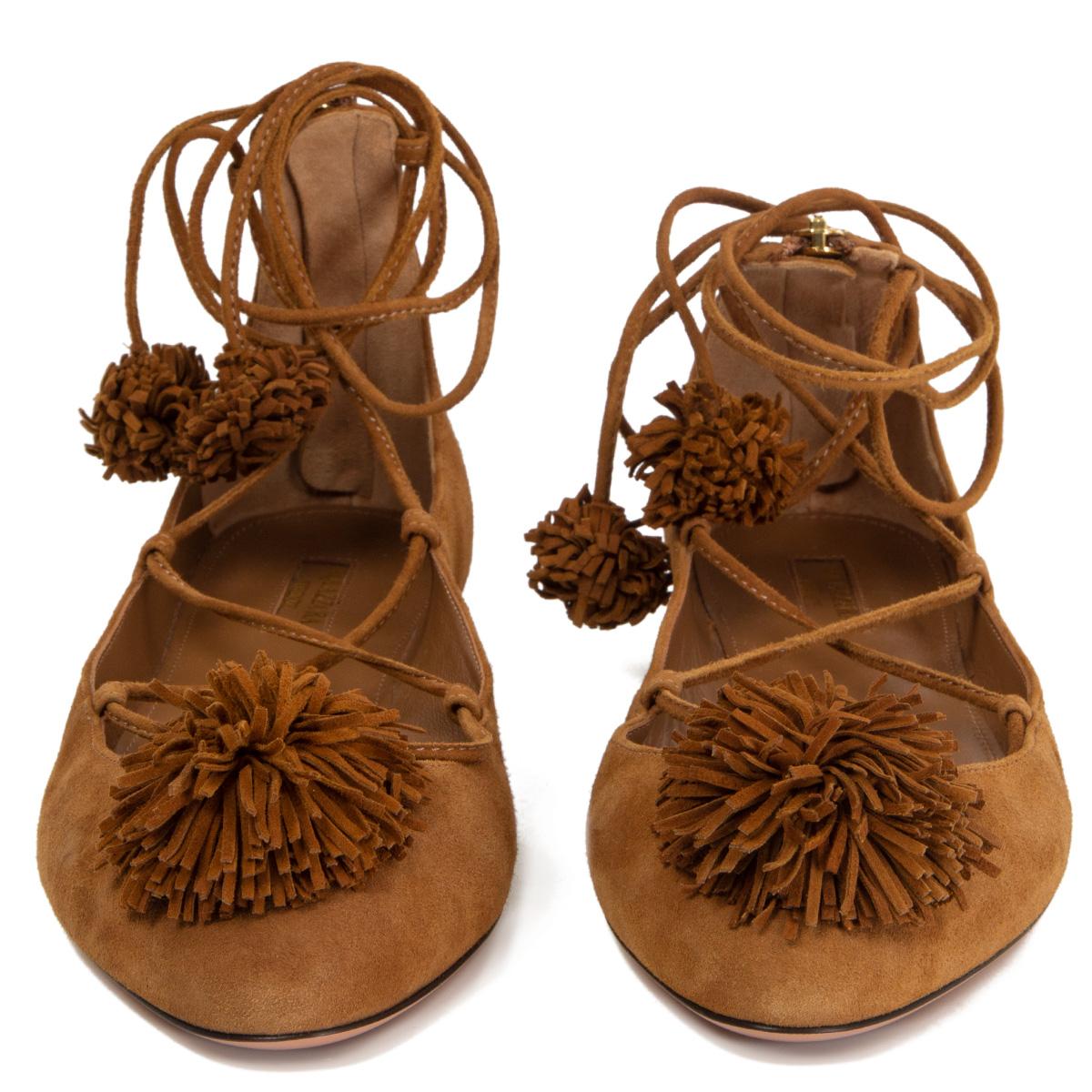 100% authentic Aquazzura Sunshine lace-up ballet flats in cognac brown suede detailed with pom-pom trims. Ghillie tie with back zipper closure. Brand new - however there is a small mark on the right shoe, on the side, near the front - see first