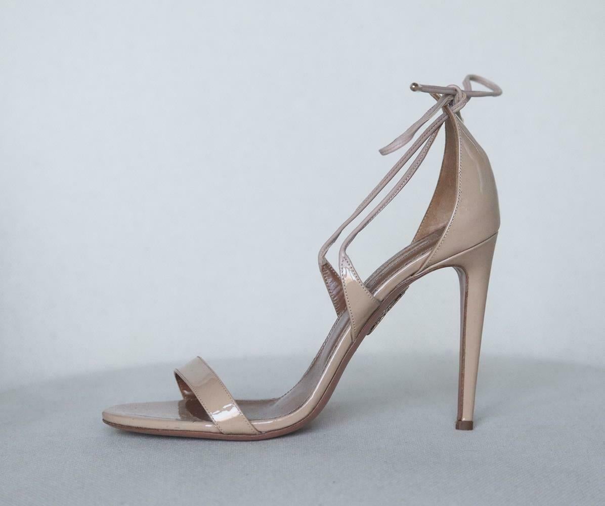 Aquazzura's coveted 'Linda' sandals are updated this season in nude, made from glossy patent-leather, they're designed with a slim toe strap and ties that elegantly frame the ankle. Heel measures approximately 105mm/ 4 inches. Nude patent-leather.