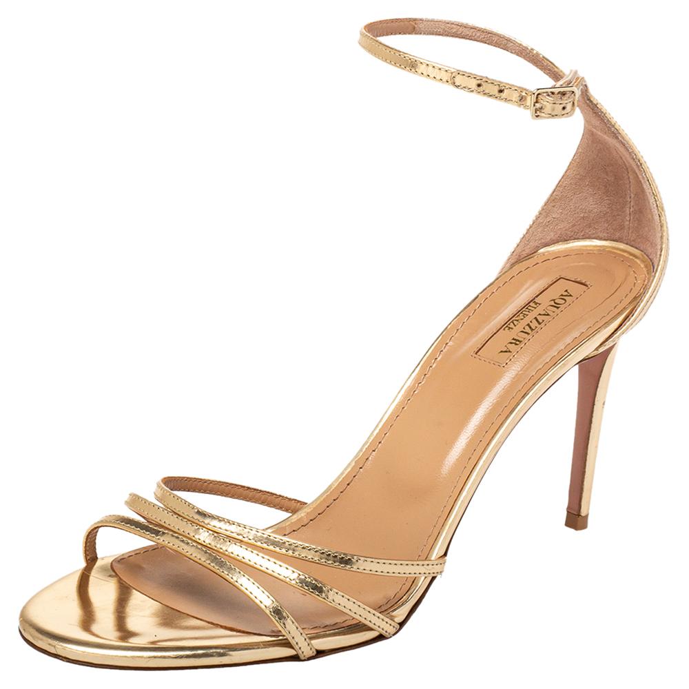 These stylish Very Purist sandals come from the house of Aquazzura. Crafted in Italy, they are made from leather in a metallic gold shade. They are styled with open toes, strappy vamps, ankle straps with buckle closures, and 9 cm heels. They are