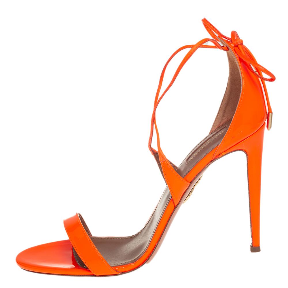 The barely-there silhouette of Aquazurra's Linda sandals is what makes them so covetable! Beautifully made from patent leather in an orange hue, they are adorned with slender straps that elegantly form an open-toe design. These sandals are secured