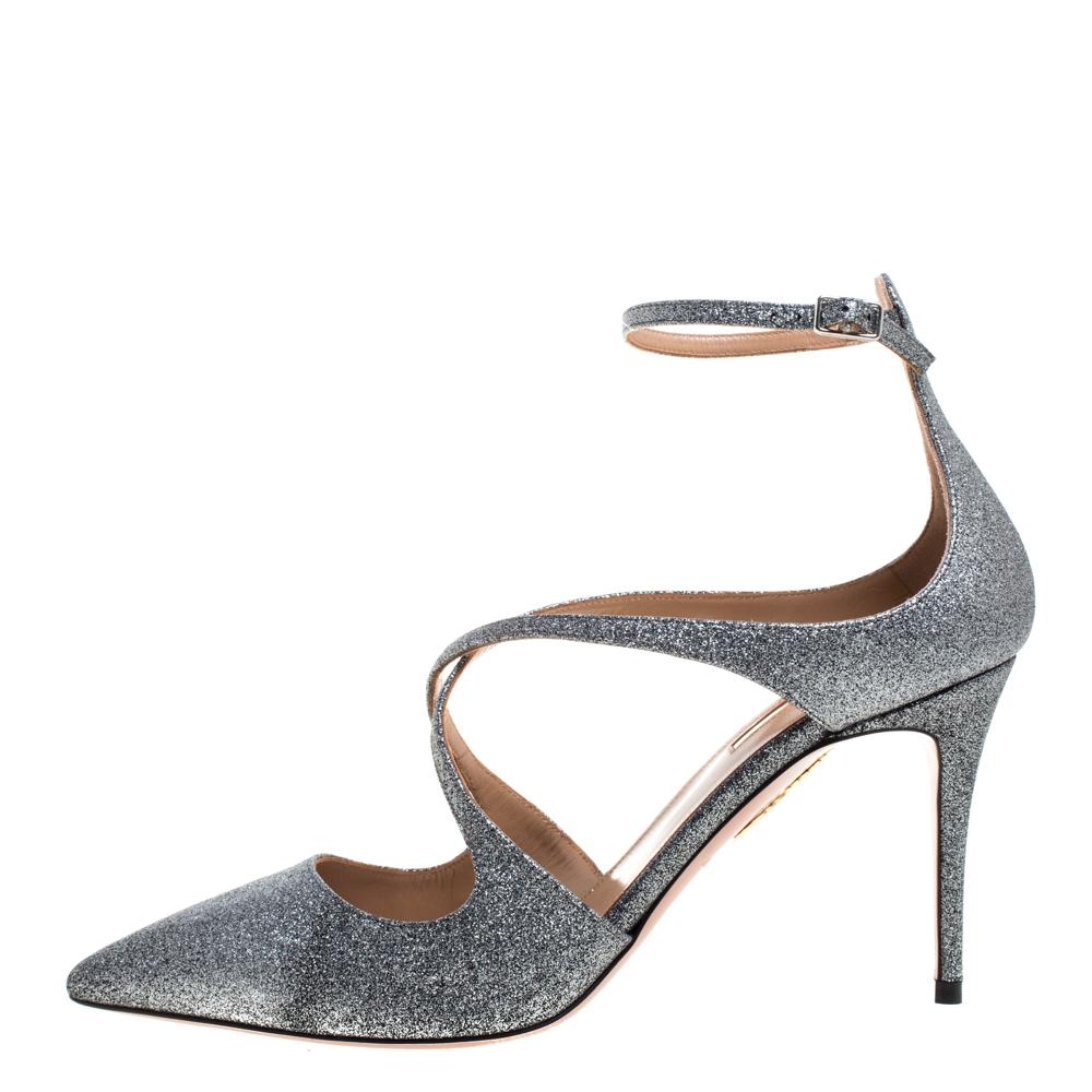 These pumps from Aquazzura are meant for seasons of comfort and style. Covered in silver glitter, they feature pointed toes, cross straps, ankle fastening, and 9 cm heels meant to elevate you with ease. These pumps are a