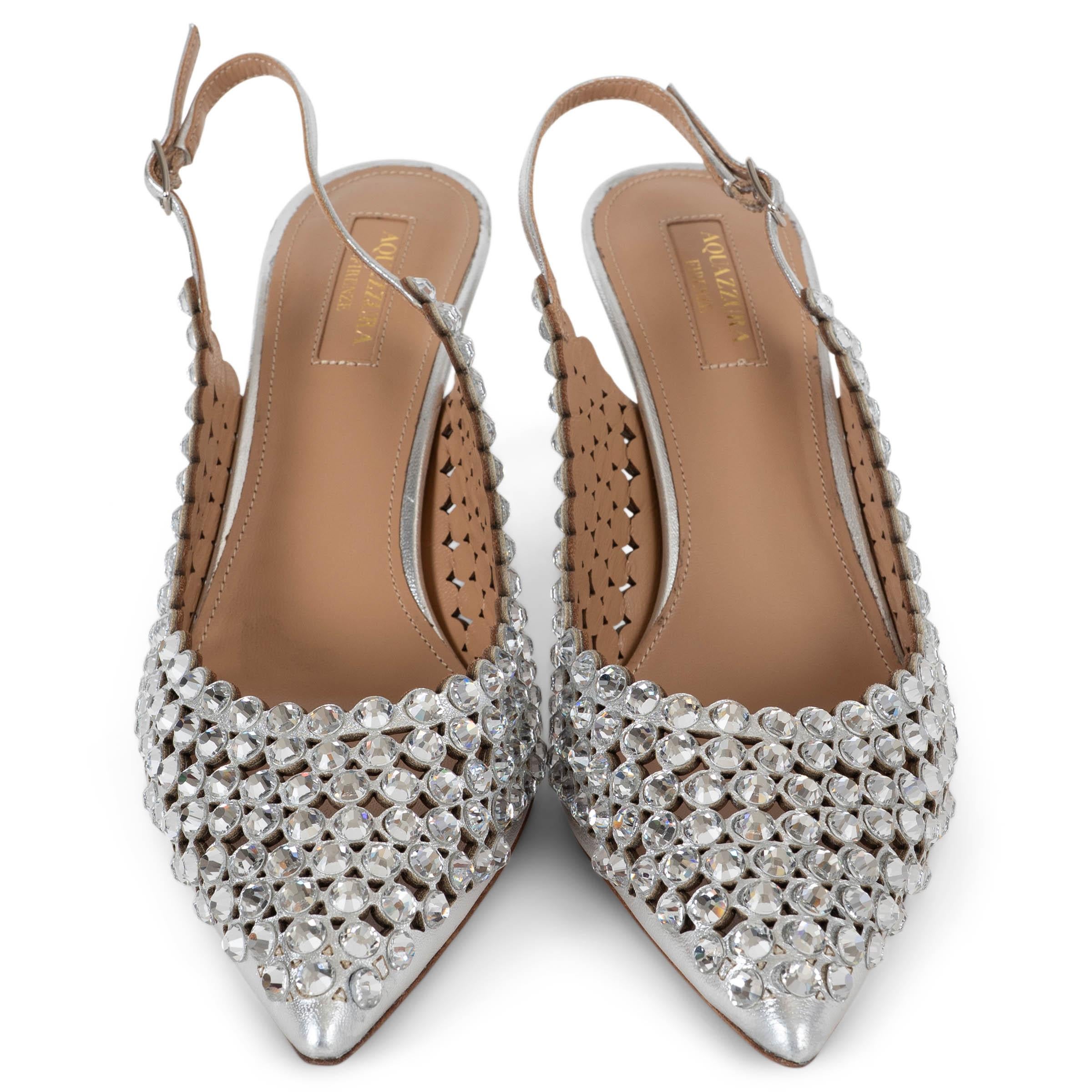 Questa slingback Tequila 85 di Aquazzura, autentica al 100%, è realizzata in pelle argentata metallizzata e impreziosita da decorazioni in cristallo trasparente disposte a raggiera. Il design è caratterizzato da una punta appuntita e da un sottile