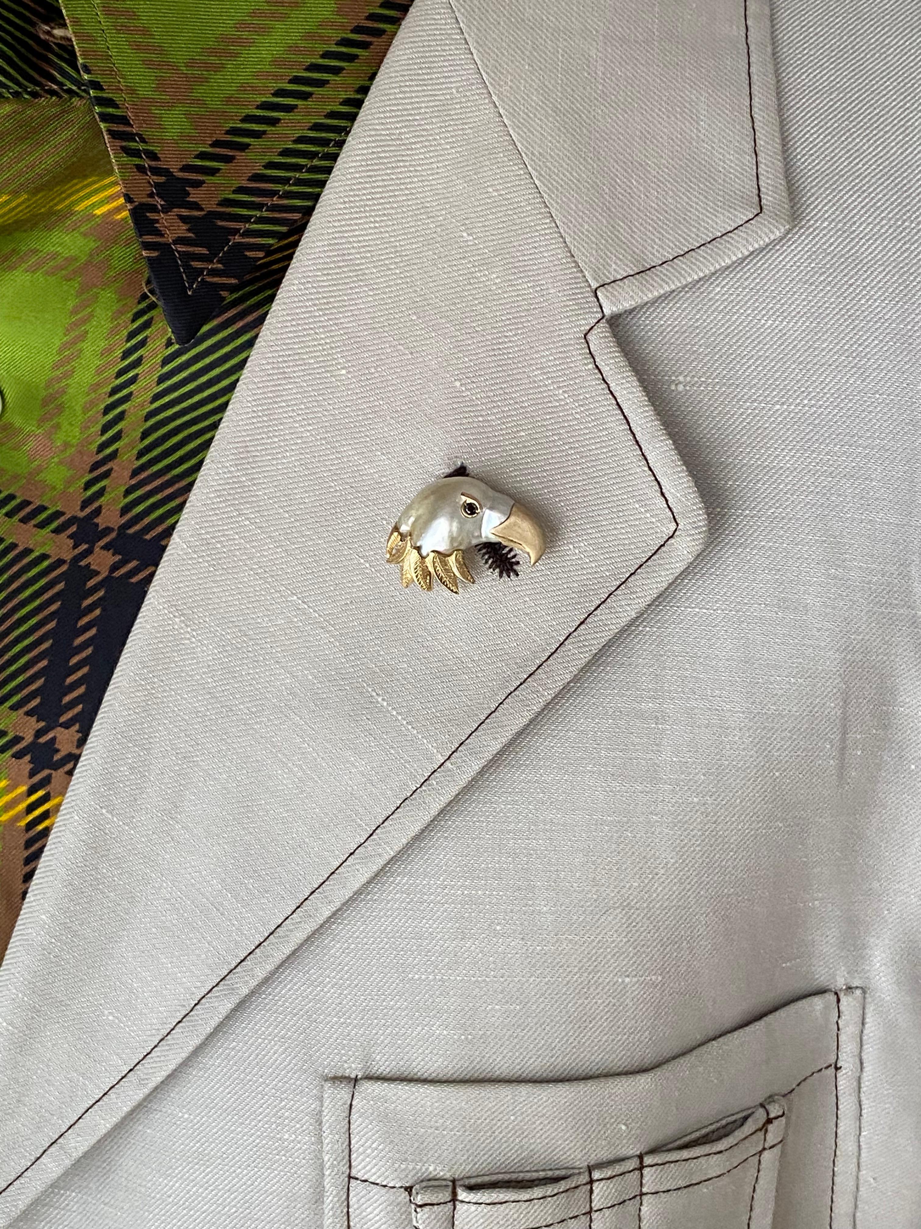 Using a 19x14 mm keshi pearl, I made the head of an eagle by adding the beak and neck plumage and eye in 18Kt yellow gold. The beak is satin-finished while the feathers are hand engraved with a burin. The eye is a black diamond set in a gold eyebrow