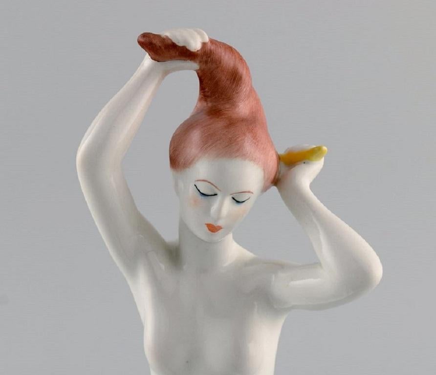 Aquincum, Budapest. Hand-painted Art Deco porcelain figurine. 
Naked woman combing her hair. 1940s.
Measures: 22 x 15 cm.
In excellent condition.
Stamped.