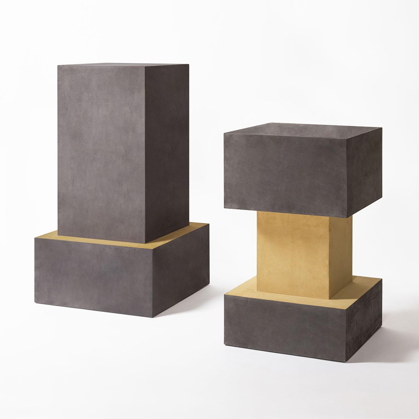 The Ara plinths boast primal monolithic volumes with rigorously geometric lines which make them able to enhance anything on display and to be solid statement pieces themeselves designed by Simone Fanciullacci. It has a leather-covered wood