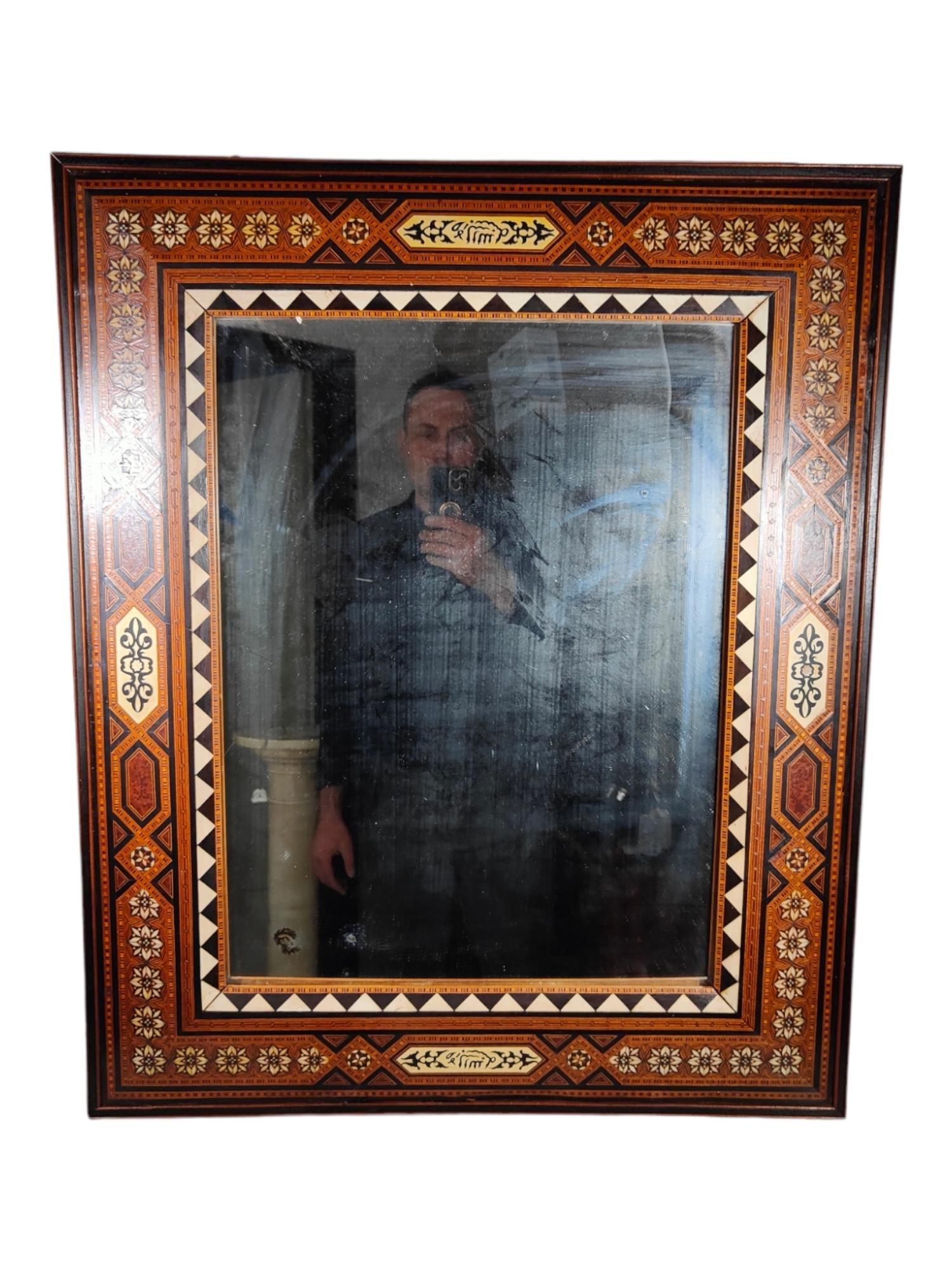 Un élégant miroir arabe à la marqueterie complexeL'élégant miroir arabe à la marqueterie complexe est fabriqué à partir de bois exotiques et d'os sculptés. Cette pièce exquise est un bel exemple de l'artisanat grenadin de la fin des années 1800 en