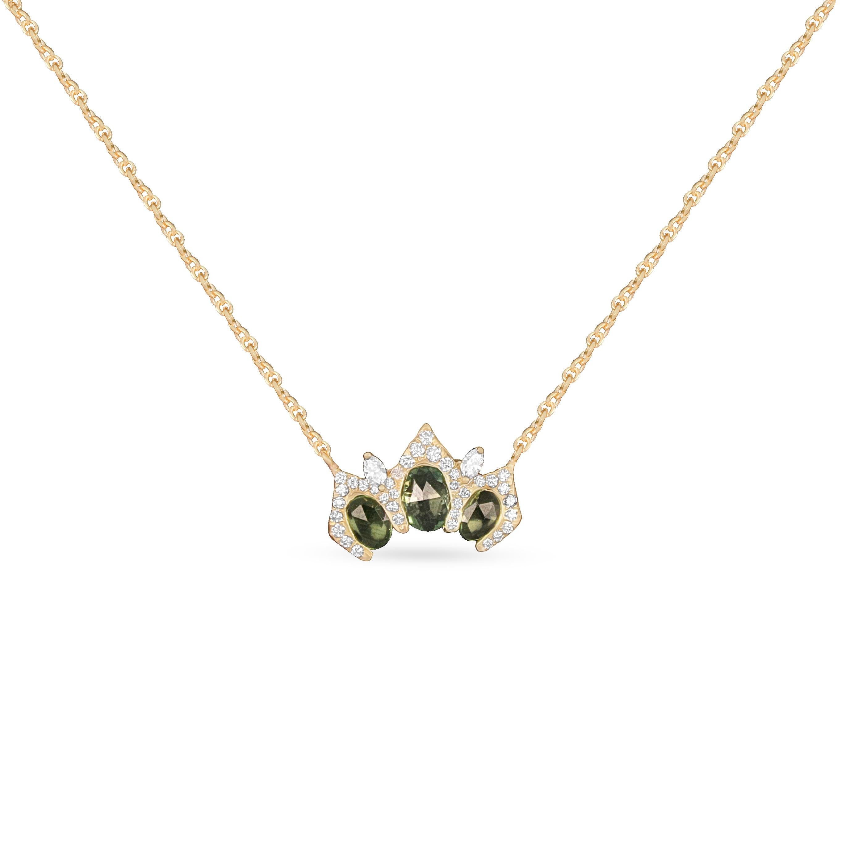 Elevate your fine jewelry collection with this exquisite Arabesque pendant necklace, masterfully crafted in 18k yellow gold. The centerpiece showcases a trio of rich green sapphires in mixed oval and pear cuts, gracefully arranged in a