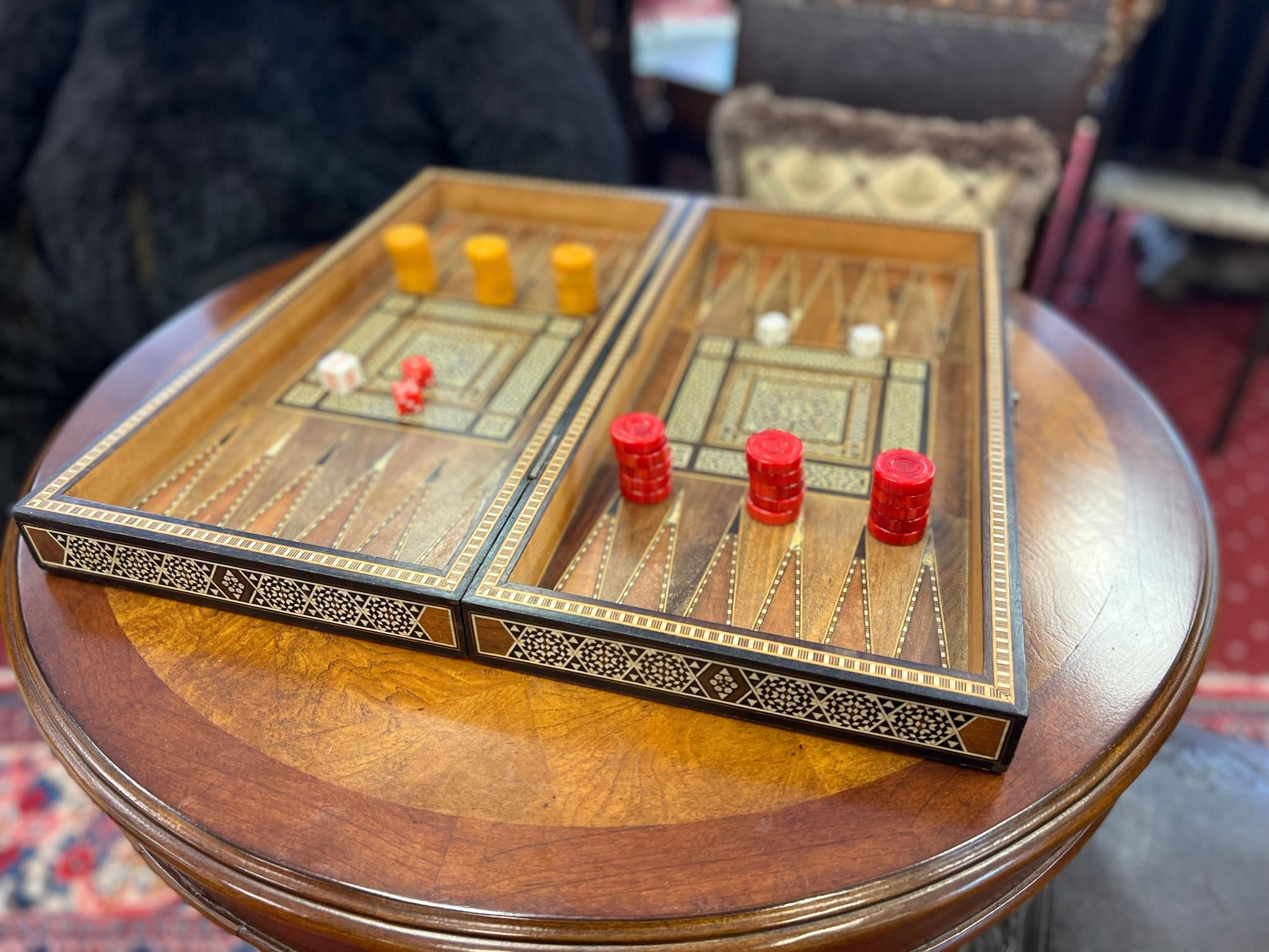 Experience the artistry of Middle Eastern craftsmanship with this exquisite hinged box featuring intricate mother-of-pearl marquetry in a micro mosaic design. This elegant piece opens to reveal a meticulously crafted backgammon game board, complete