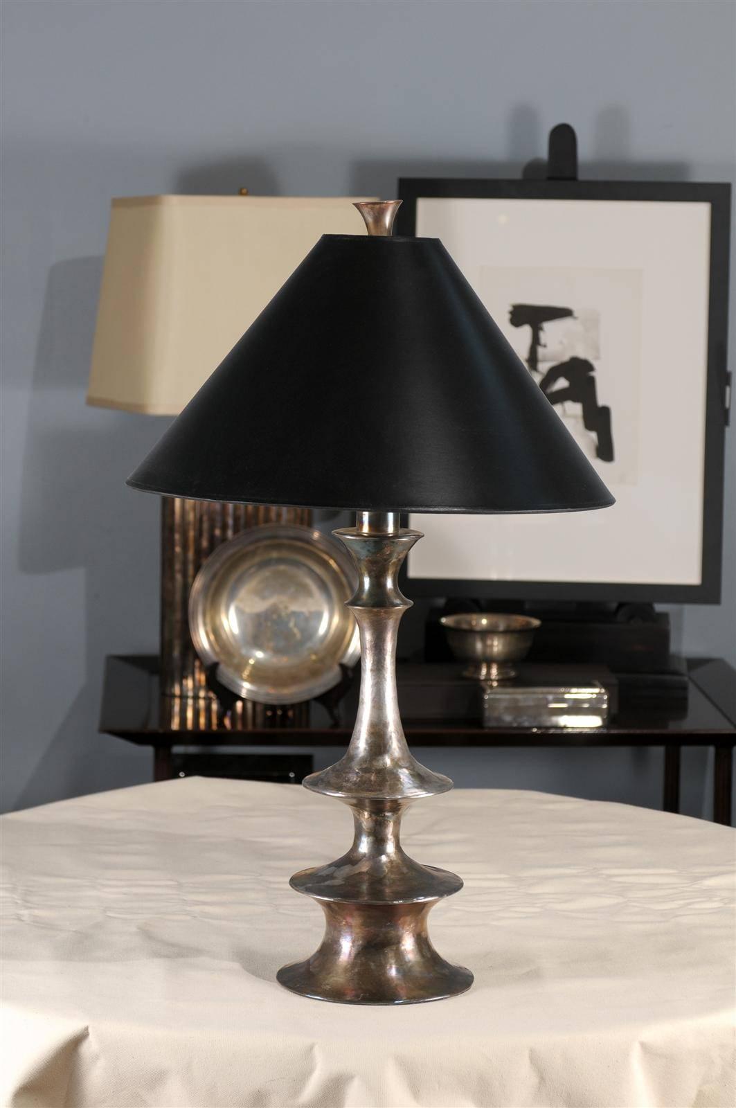 The fluid, curvilinear form of this grand table lamp is reminiscent of fanciful, decorative spindles. Yet while the inspiration may be traditional in feel, the proportions and asymmetry are unabashedly contemporary. The black copper lamp is paired