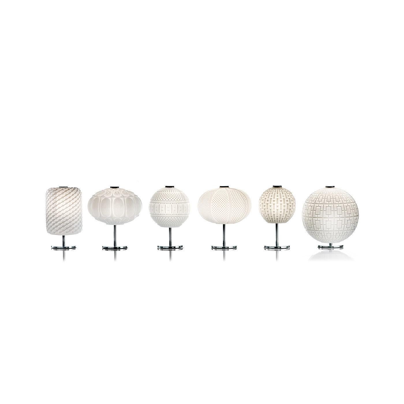 Con un fascinante motivo guilloché, esta exquisita lámpara de sobremesa tiene una impresionante pantalla elíptica de cristal de Murano blanco como la nieve, fabricada según las técnicas tradicionales de los maestros sopladores de vidrio. La