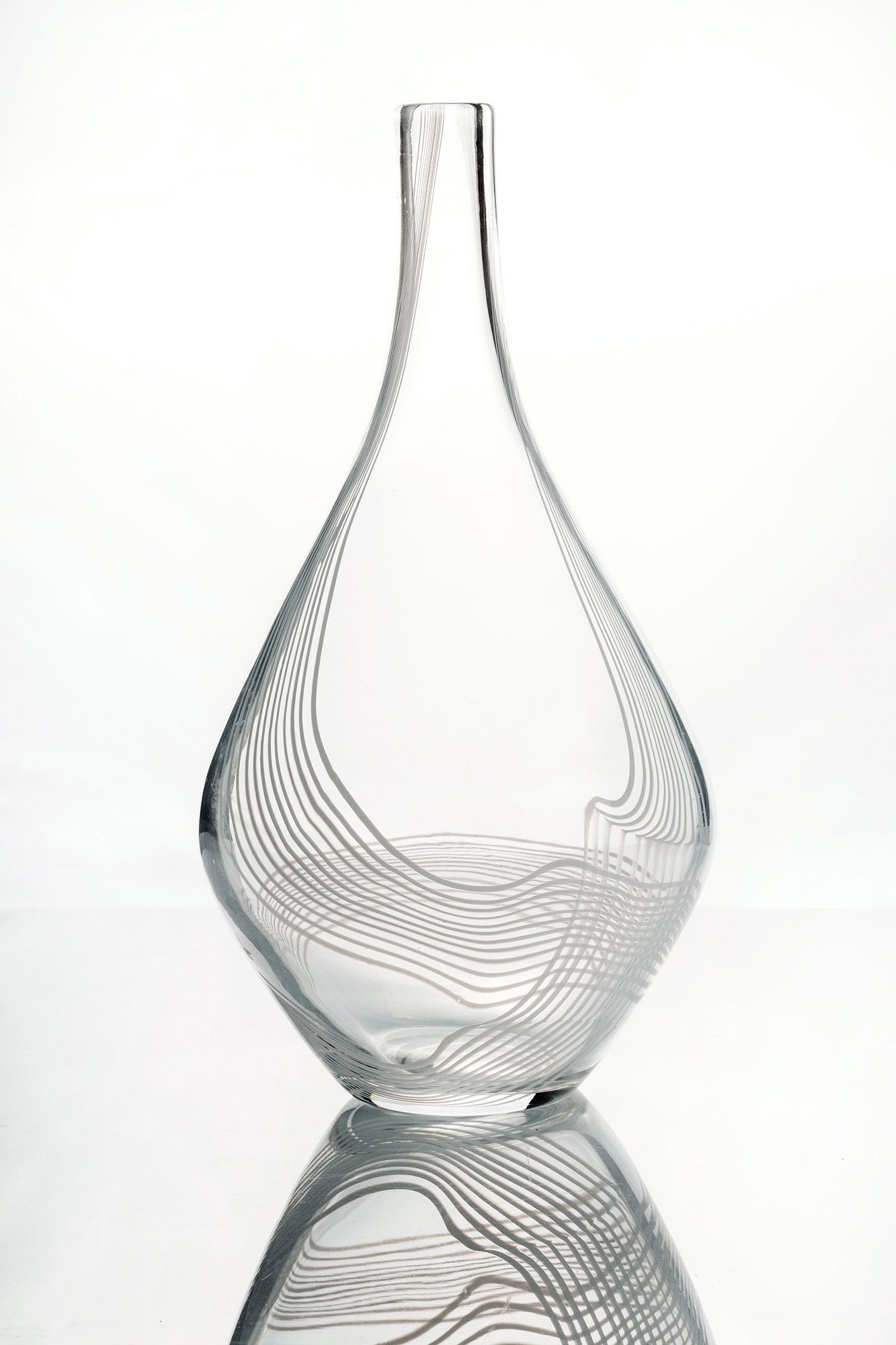 Drop shaped “Arabesque” vase, transparent glass with embedded threads in opal white glass. 
Signed Kosta LH 1034 Lindstrand Kosta.