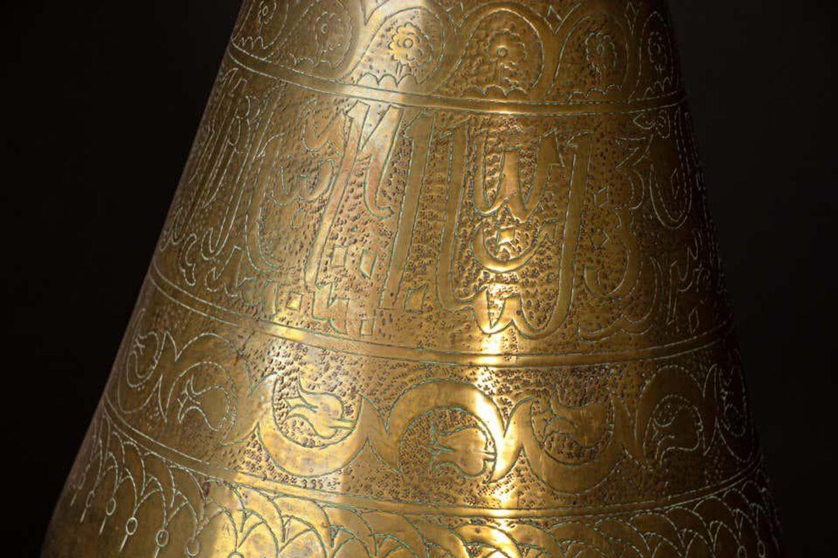 Middle Eastern Islamic brass repousse bowl, finely hand-etched, engraved, hammered and chased with elaborate Moorish designs decorated with medallions of Arabic calligraphy inscriptions.
The brass vase features two handles delicately