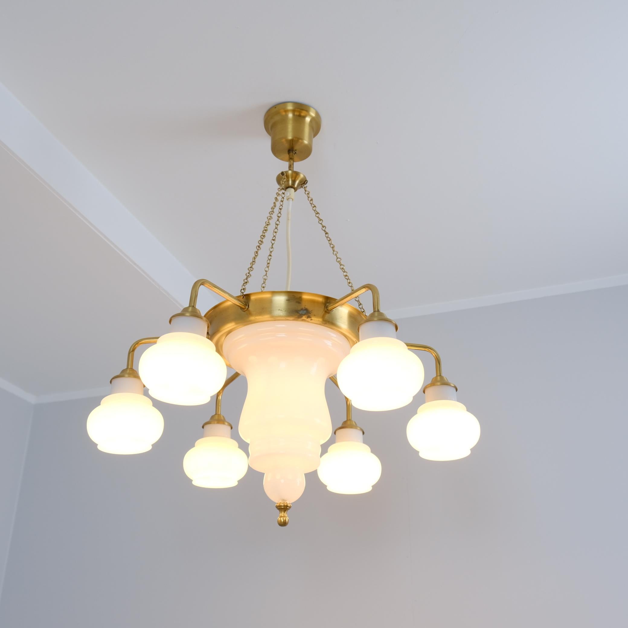 Un magnifique et rare lustre de style lanterne des 1001 Mille et une nuits, avec une touche de modernisme, fait de laiton et de verre opalin. La lampe est fabriquée par Ker-Lux Mänttä et a très probablement été conçue par Kai Ruokonen, qui était