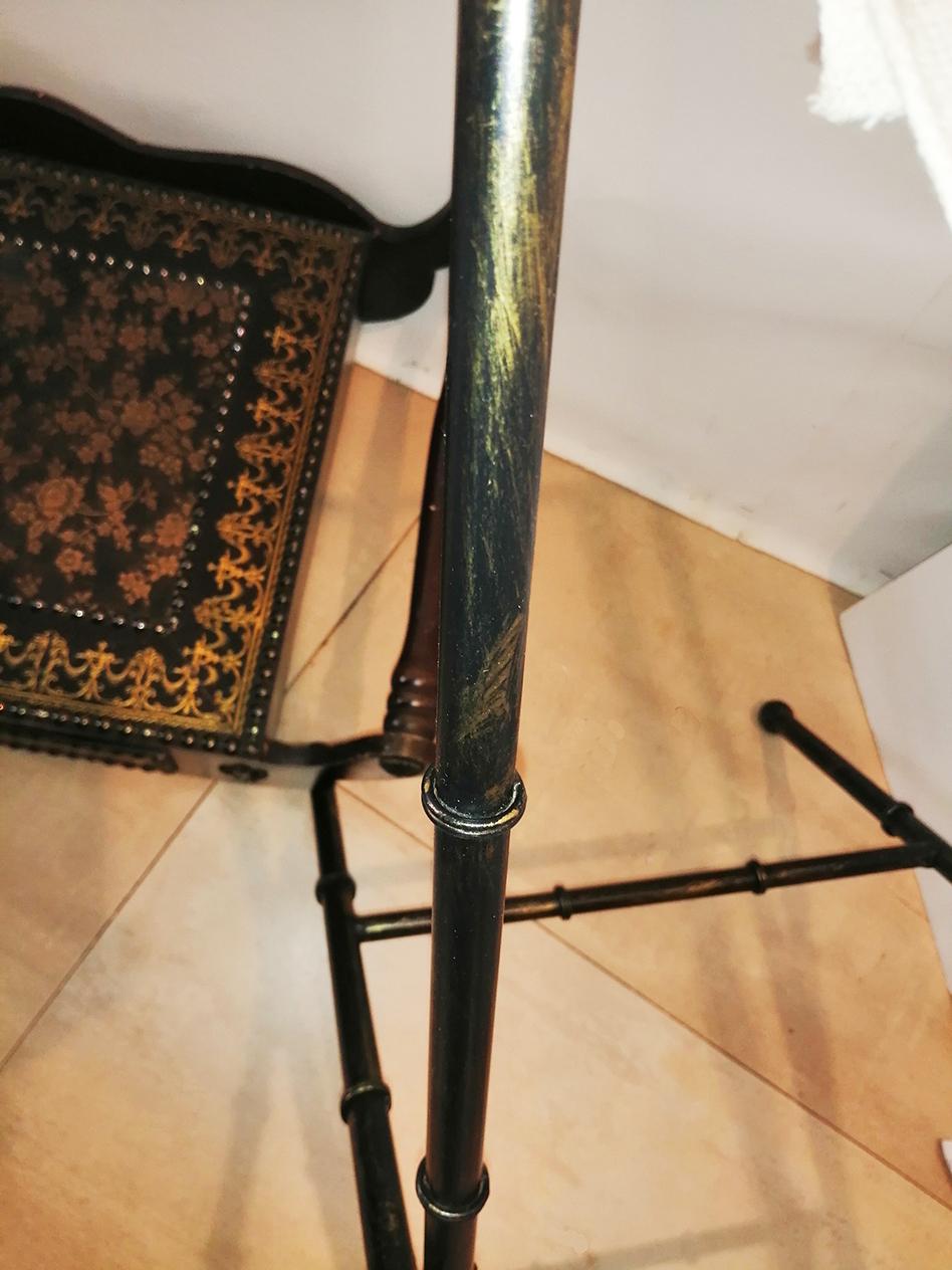 This tray table with two drawers. that rests on plagueble metal legs shaped like faux bamboo

The upper part is covered with a type of foot or similar to leather stamped with golden drawings
It has some minimal loss of wear in the print, it is not