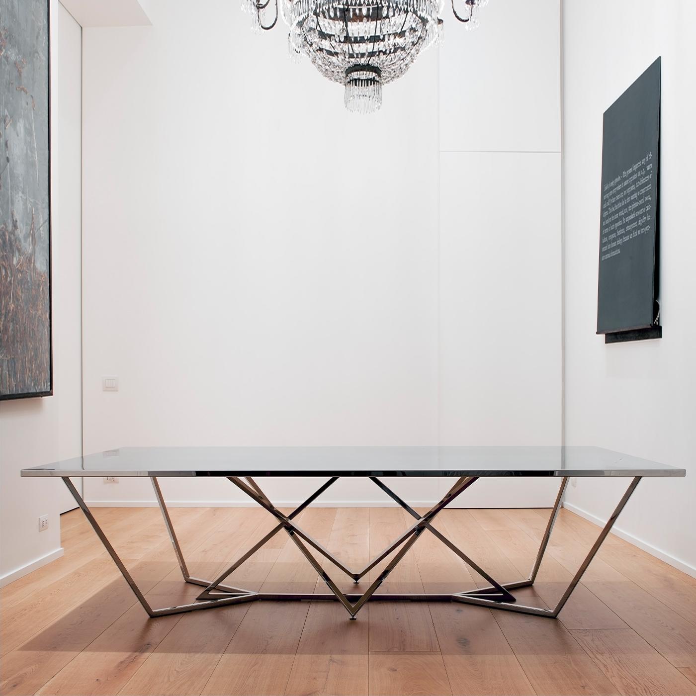 An intriguing spider-web-like steel structure lends this stately table its distinctive sculptural appeal. Perfect as a conference table in stylish professional contexts, it boasts a glossy finish on the frame that sustains a bold rectangular top