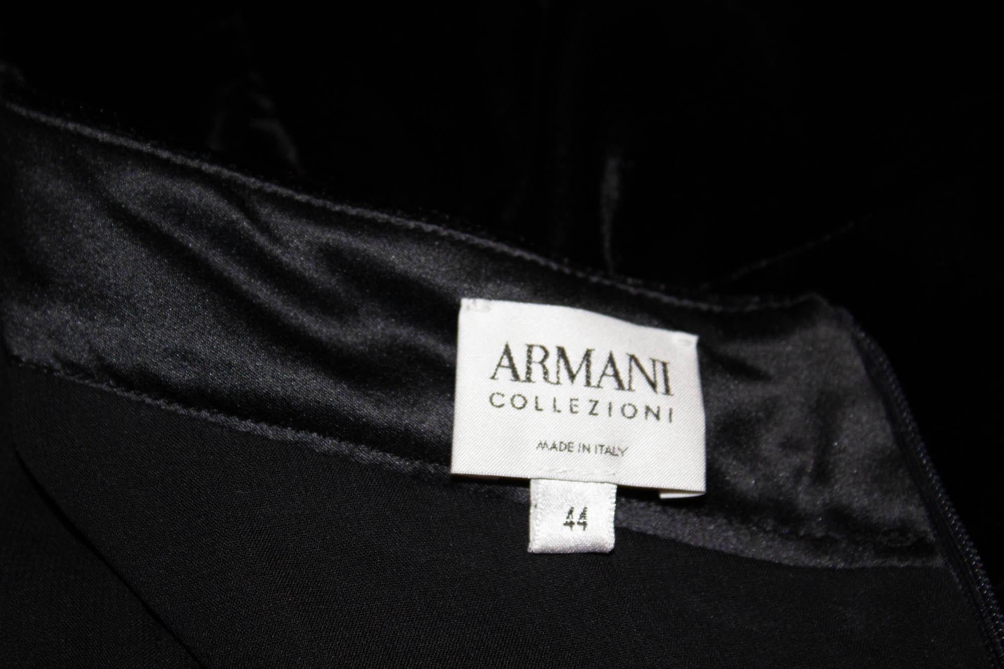 A stunning black velvet cocktail dress by Giorgio Armani, Armani Collezionni line. The dress has a v neckline with a crossover front, puff sleaves and A line skirt area. It is fully lined with a back central zip. Size Eu Italian 44, Measurements: