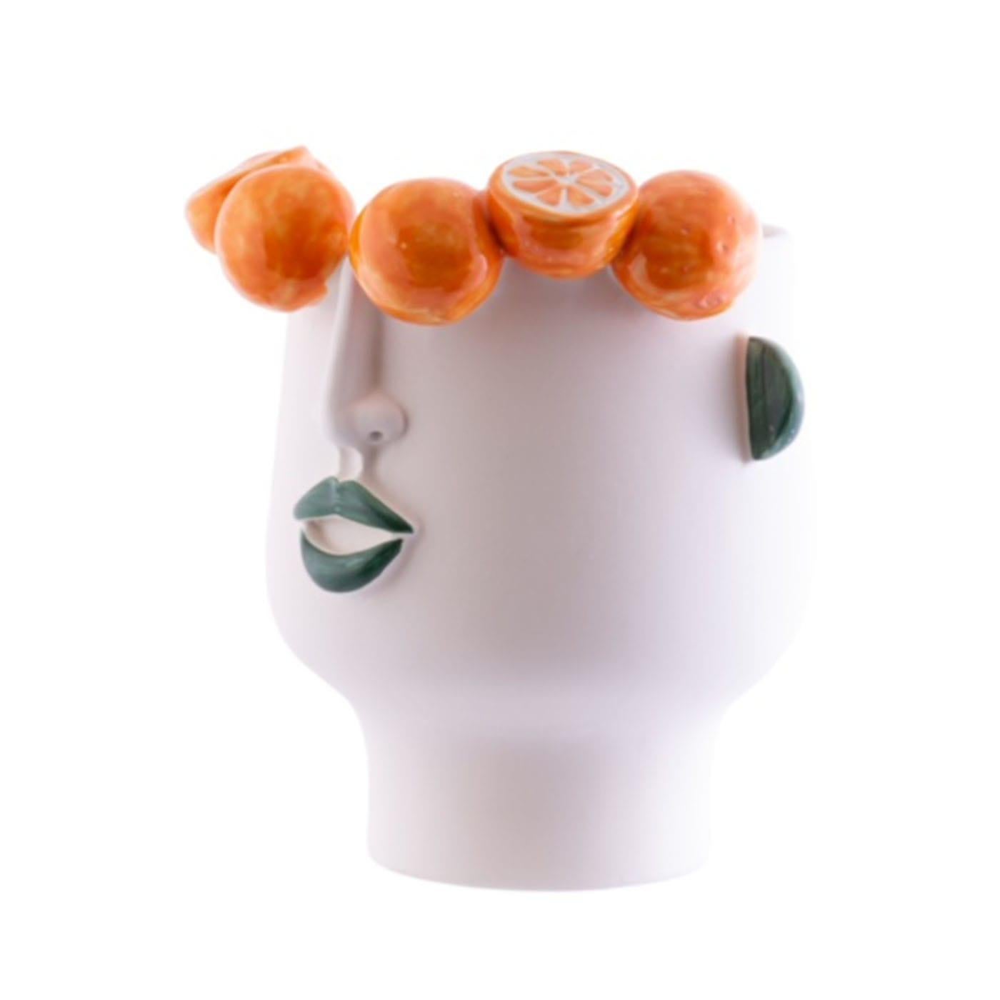 This large figurative vase is a captivating piece adorned with a stylized face and raised oranges, highlighted by a matte cream glaze and colorful crystals. Its spacious interior can accommodate water, making it an excellent vessel for flowers or