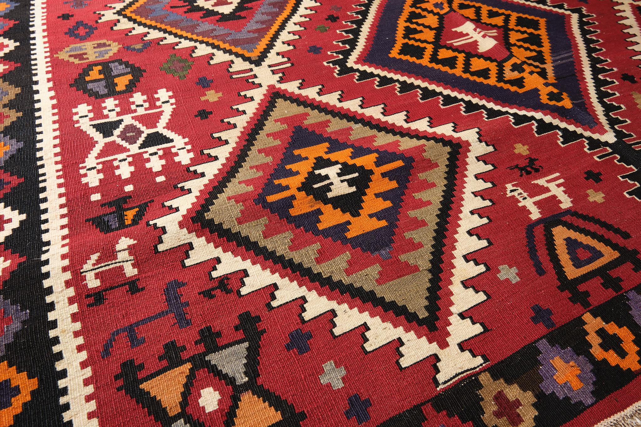 Si tratta di un antico kilim caucasico di grandi dimensioni proveniente dalla regione di Kuba con uno sfondo rosso e una bellissima composizione di colori.

I kilim Kuba sono spesso decorati con grandi medaglioni astratti frastagliati disposti in