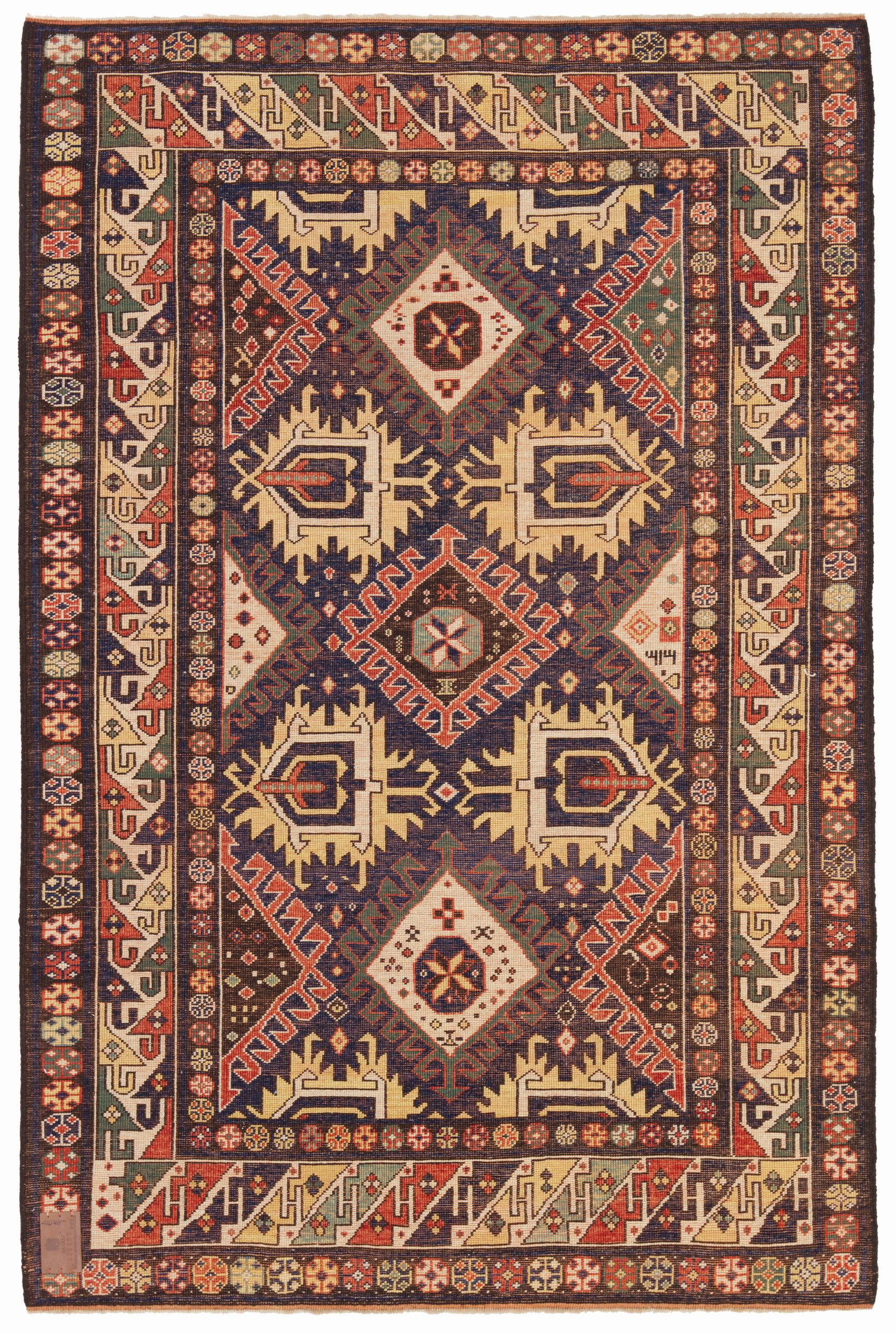 Dies ist ein Derbend-Kazak-Teppich, der auch als Daghestan-Teppich bekannt ist. Er wurde Ende des 19. Jahrhunderts entworfen und ist eine Art handgewebter Teppich, der aus der Kaukasusregion stammt, insbesondere aus der Stadt Derbend (auch Derbent