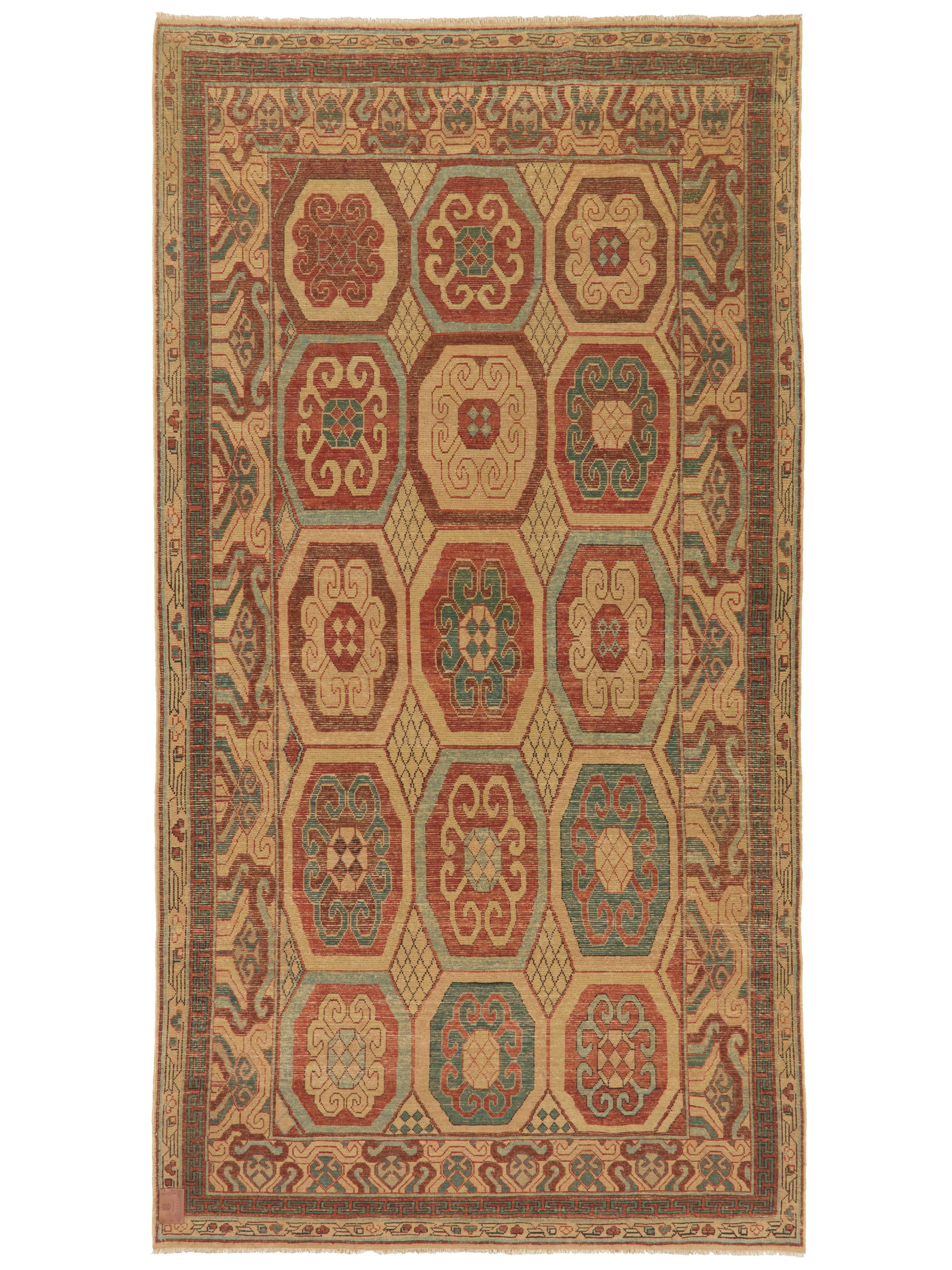 Expression intemporelle de l'art de la route de la soie, ce tapis Khotan noué à la main s'inspire des traditions textiles raffinées du Turkestan oriental. Son design jette un pont entre les cultures, fusionnant les bandes de nuages chinoises, les