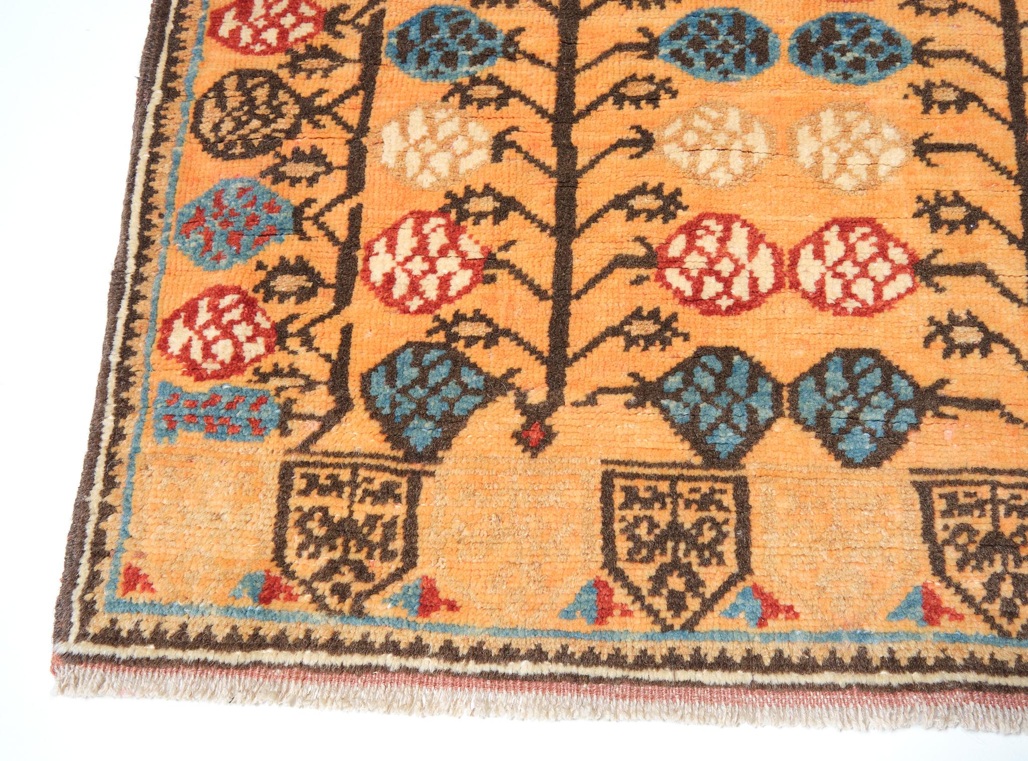 This is a popular design employed by the Turks, a 17th century rug from Turkey, Central Anatolia area. Stylized pomegranate trees with flowers and fruits, many diverse colored floral figures on an orange ground with both ends prayer arch (mihrab)