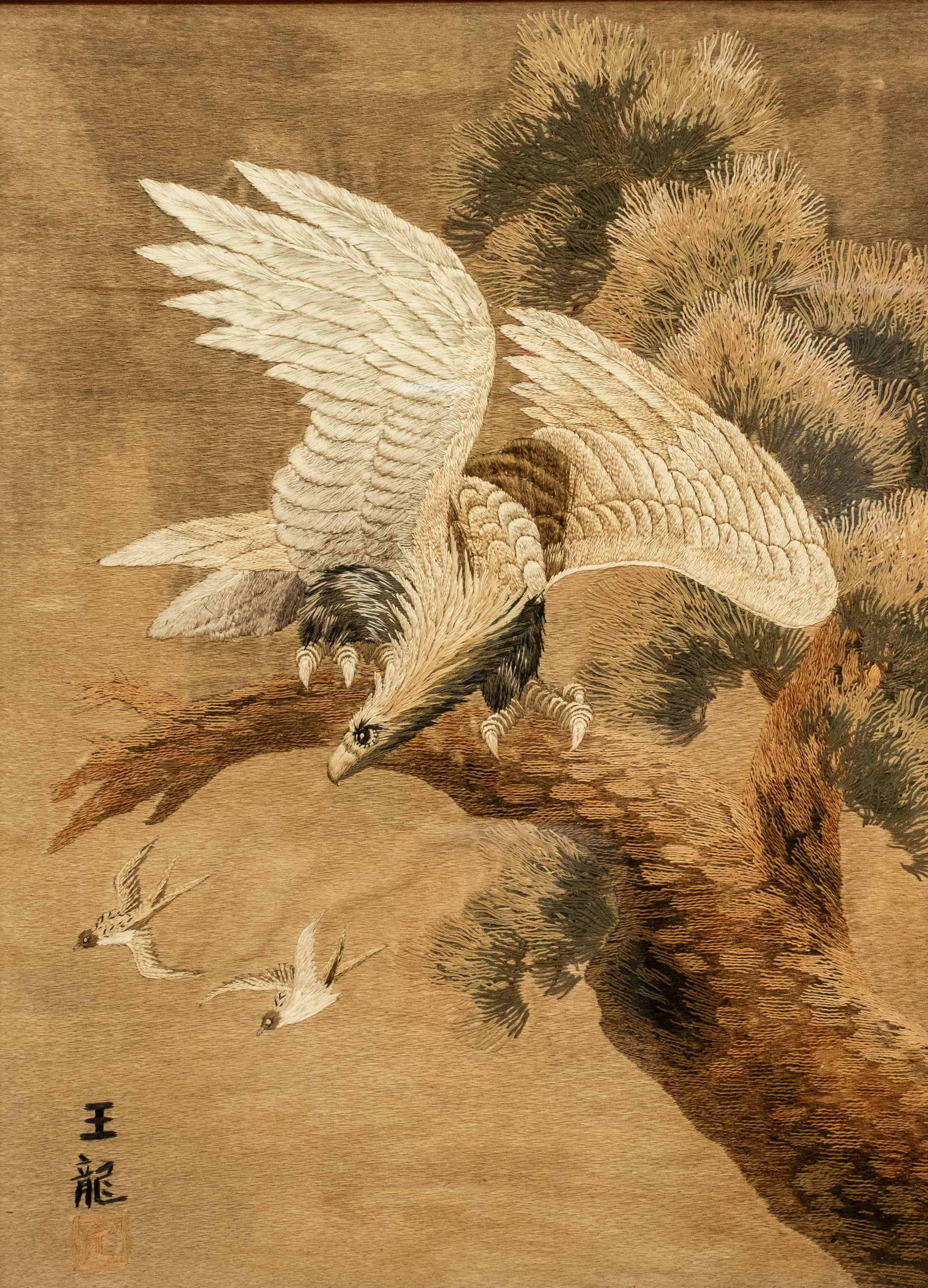 Arazzo giapponese ricamato in seta policroma su fondo in tessuto chiaro, raffigurante un’ aquila pronta a spiccare il volo da un ramo di pino (matsu), mentre osserva due piccoli uccellini in volo.

Firma ricamata in basso a sinistra.

Periodo: Meiji