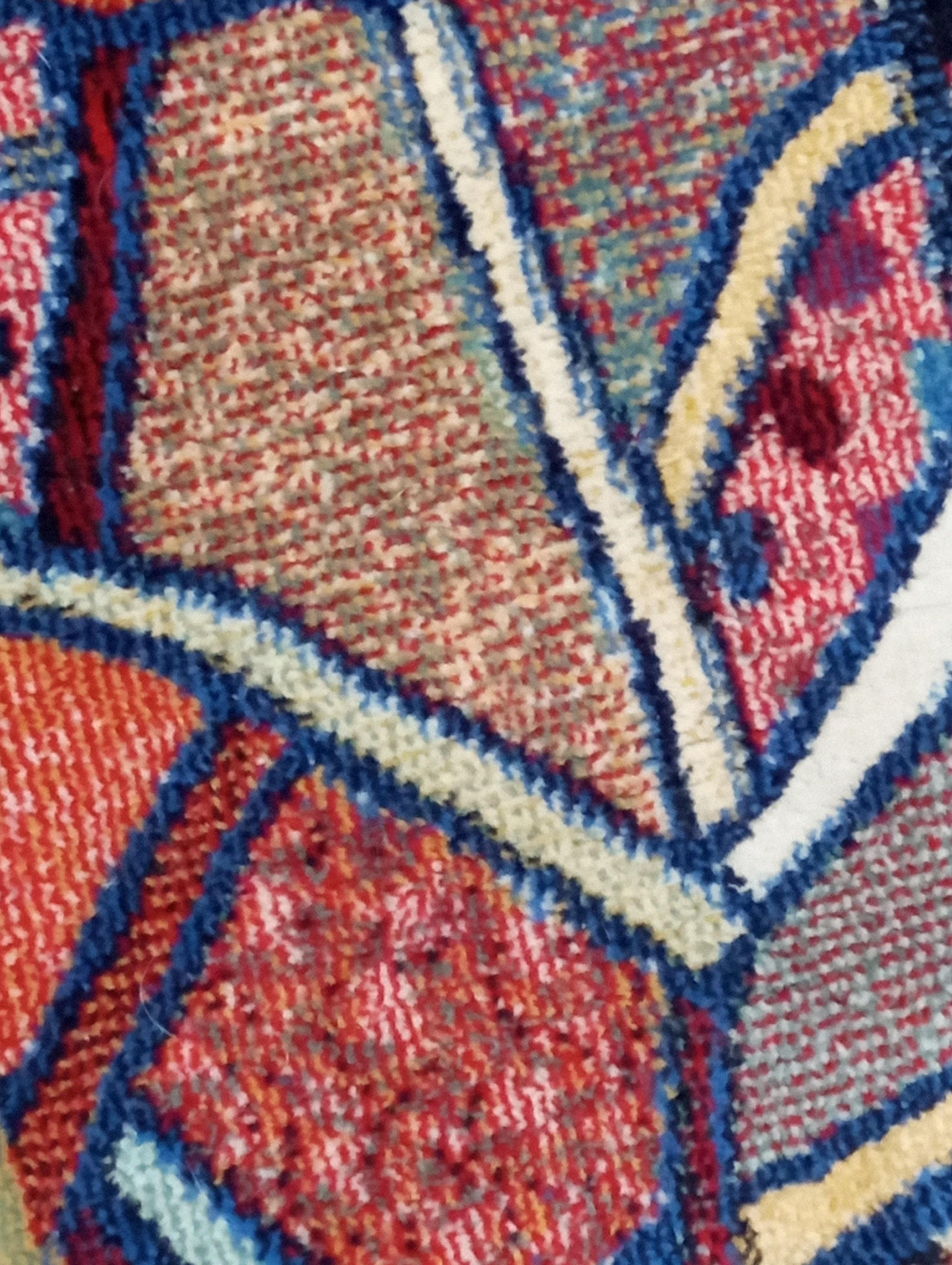 This abstract wool tapestry rug is an elegant European creation from the 1970s, made in Italy. Featuring a design inspired by Pablo Picasso's abstract motifs, the rug features a vibrant color scheme: a border in orange hues that dynamically frames