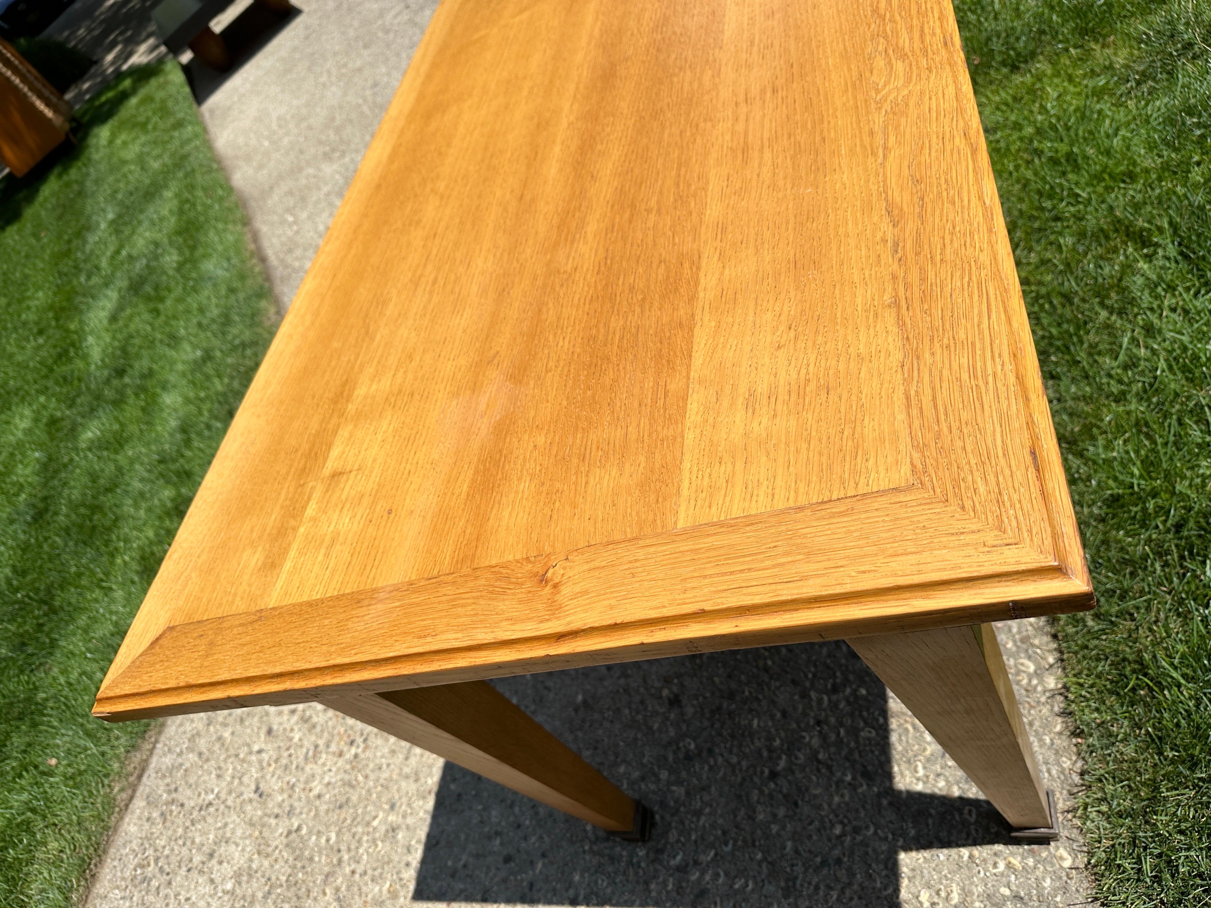 This long and narrow oak table with brass accent sabots shows a beautiful age and patina from mild use.   THIS ITEM IS LOCATED AND WILL SHIP FROM OUR EAST HAMPTON, NY SHOWROOM.