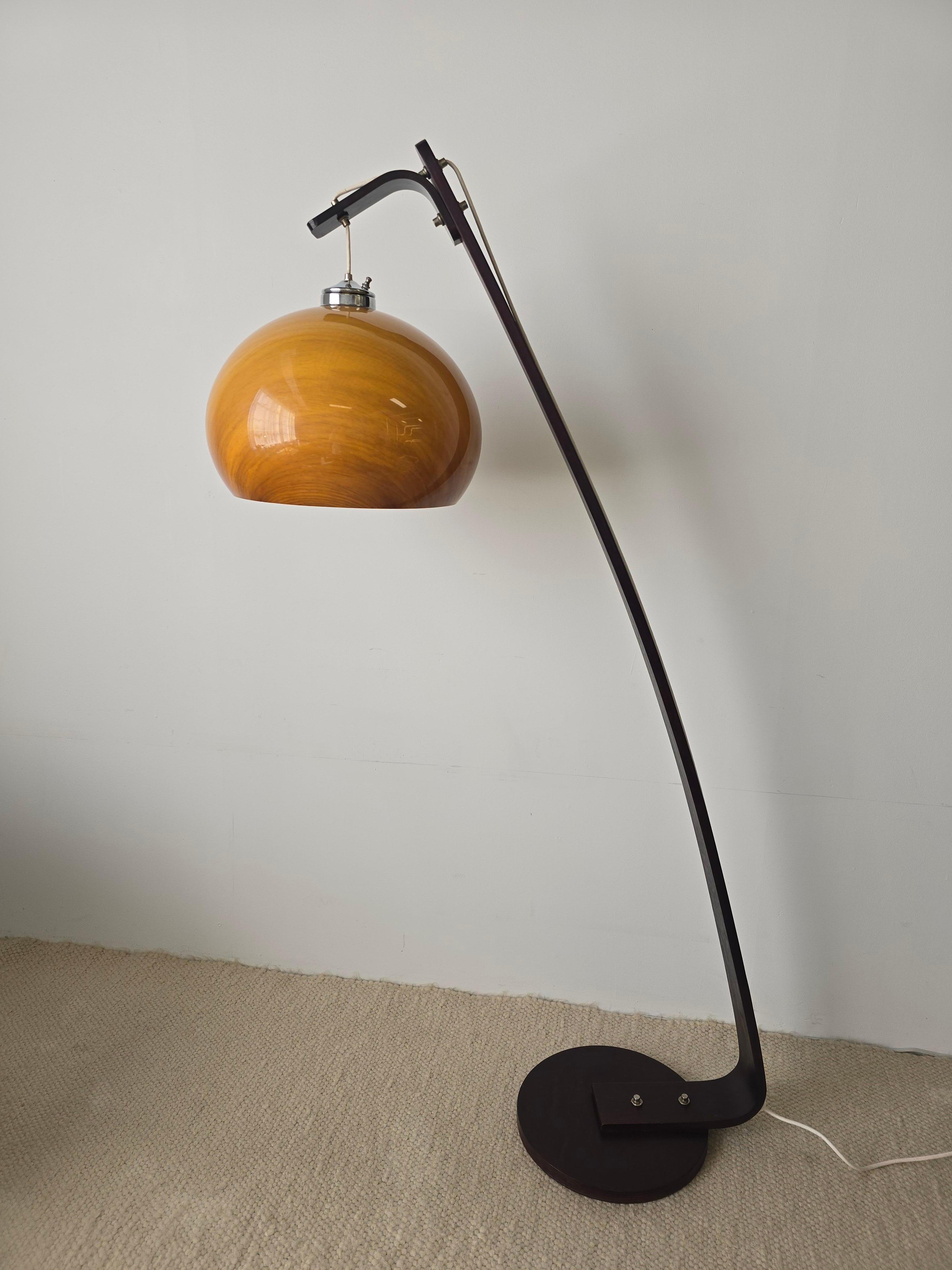 Gorgeous vintage arc floor lamp with a wooden base in dark brown/mahogany stain and an acrylic lamp shade. The woodenbase is round accompanied by a slightly arched frame which holds the large acrylic shade. The shade is finished in a beautiful amber