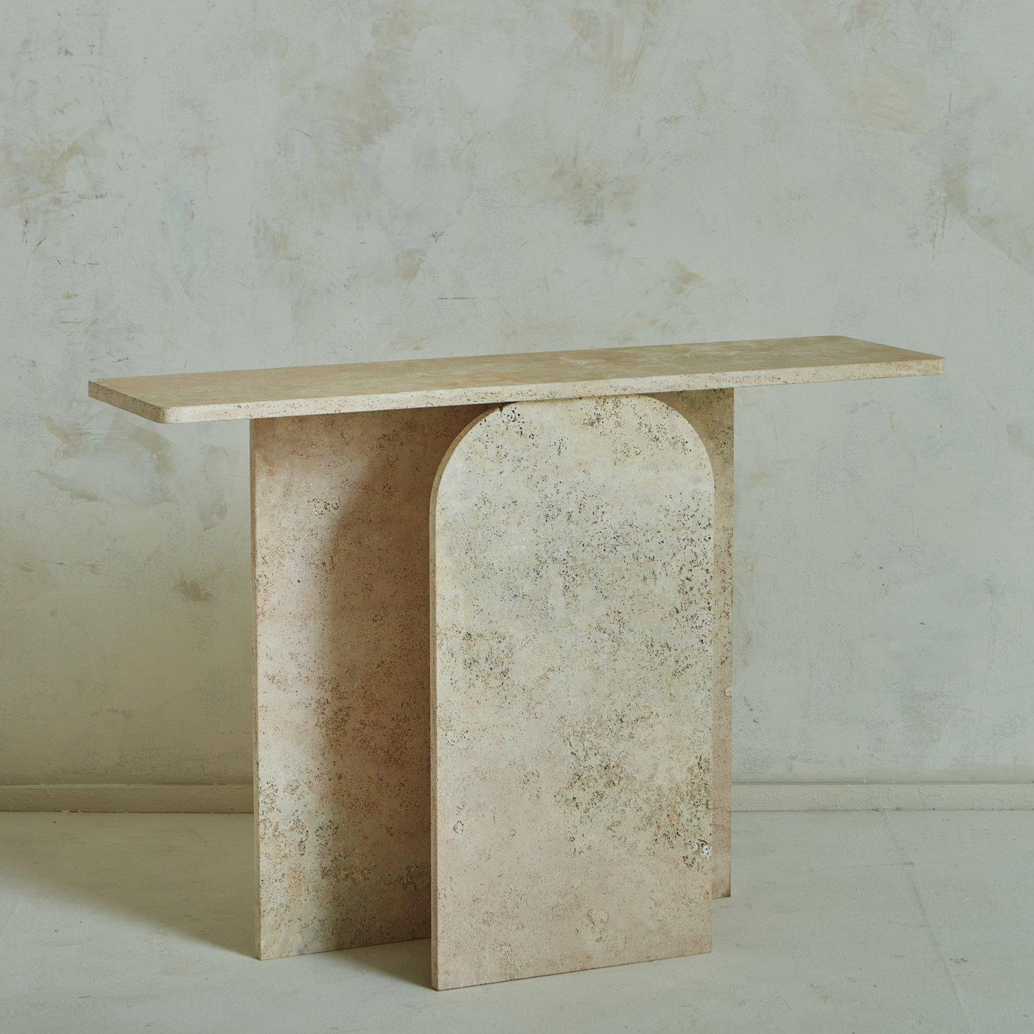 A custom console table designed in house by South Loop Loft. The Arc console was constructed with a gorgeous peachy unfilled travertine. It features a rectangular tabletop and a beautiful arched profile.

This table is available as a custom order