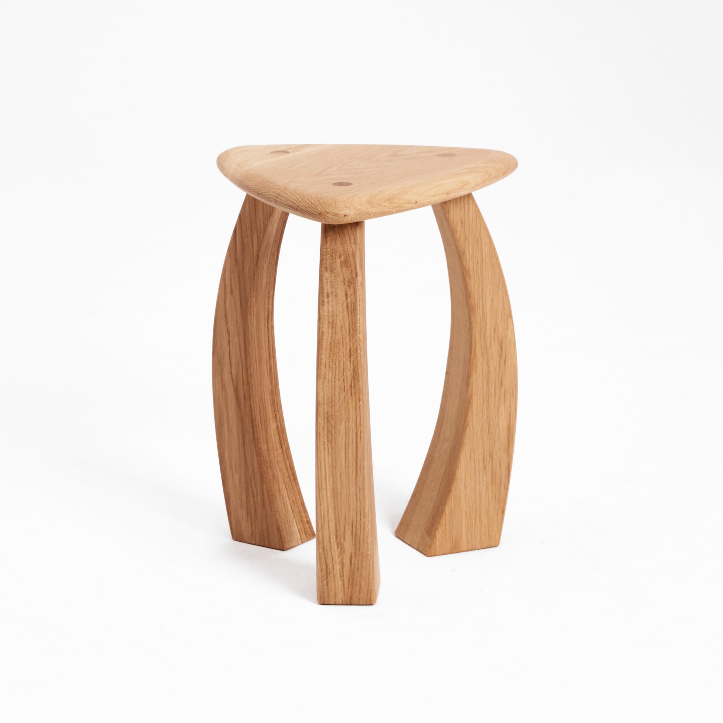 Arc de Stool 52 in Oak by Project 213A
Dimensions: D 39 x W 39 x H 52 cm
Materials: Oak wood. 

The taller version of the stool's legs curves inwards towards its triangular seat, fusing to showcase exquisite craftsmanship. The elegant complexion