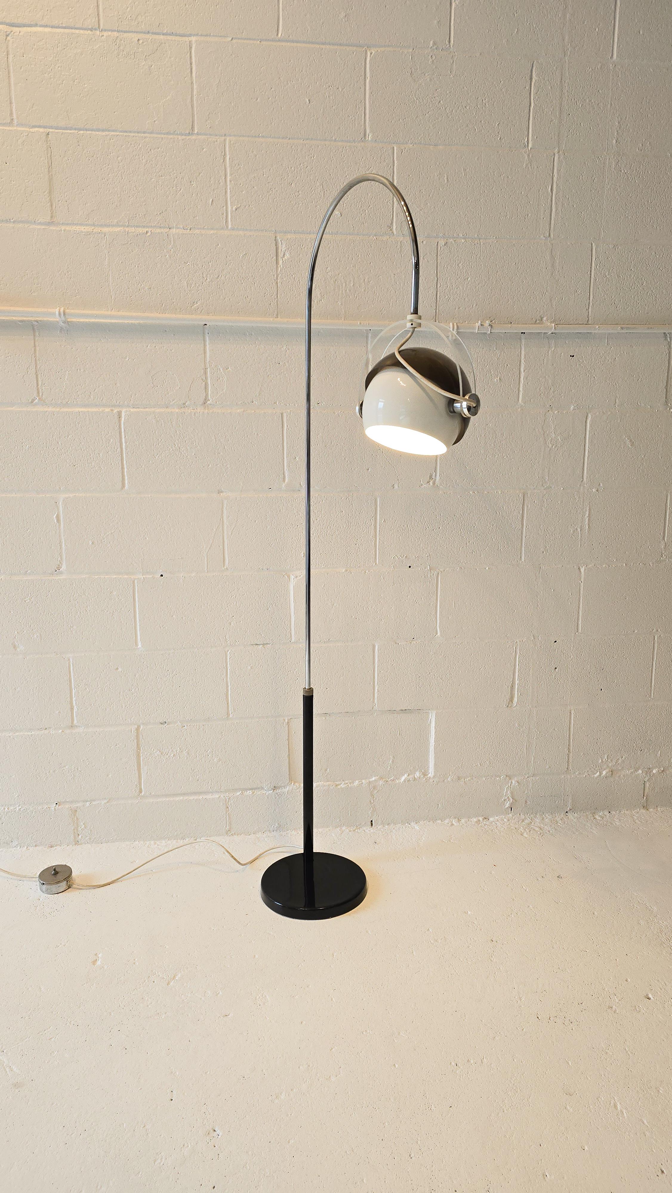 Stunning arc floor lamp featuring a lacquered black base, chrome arch and a mixture of metal, acrylic and lucite shade. The base is finished in lacquered black, the arc is in chrome. The lampshade that connects to the base has a clear lucite which