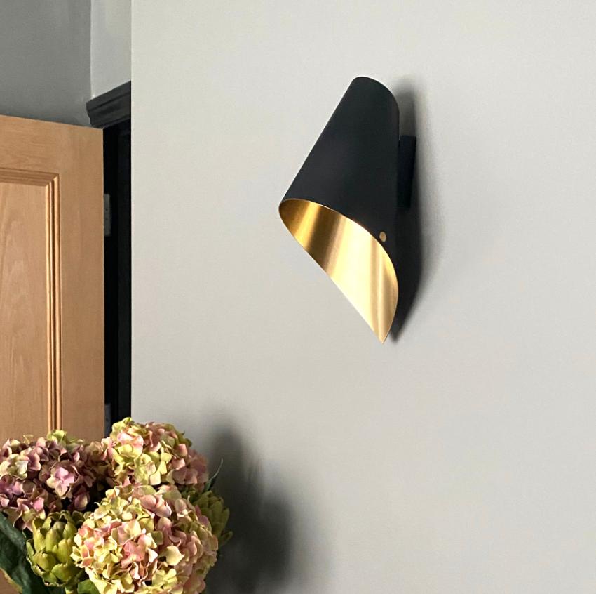This beautiful brushed brass & matte black wall light is from our debut British lighting range.

Our contemporary wall lights are perfect for bathing your home in beautiful light, maybe above your favourite chair or beside your bedside for