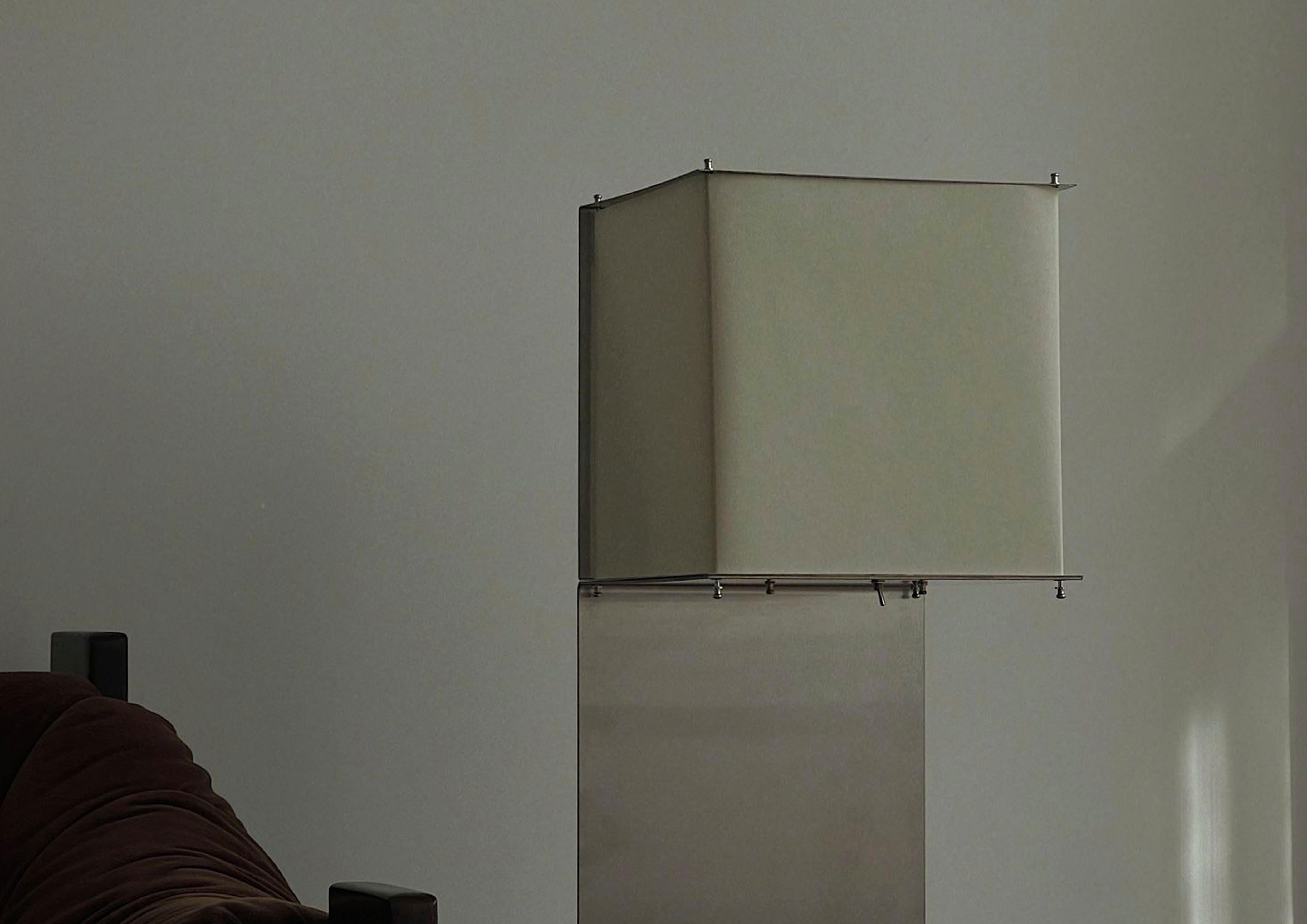 Avec des lignes géométriques précises, la lampe Arca, dernière création de Pedro Ávila (@avilapedro), établit un contraste intriguant entre l'ascendance du papier parchemin et le tranchant de l'acier inoxydable. Dans cette fusion contrastée, une