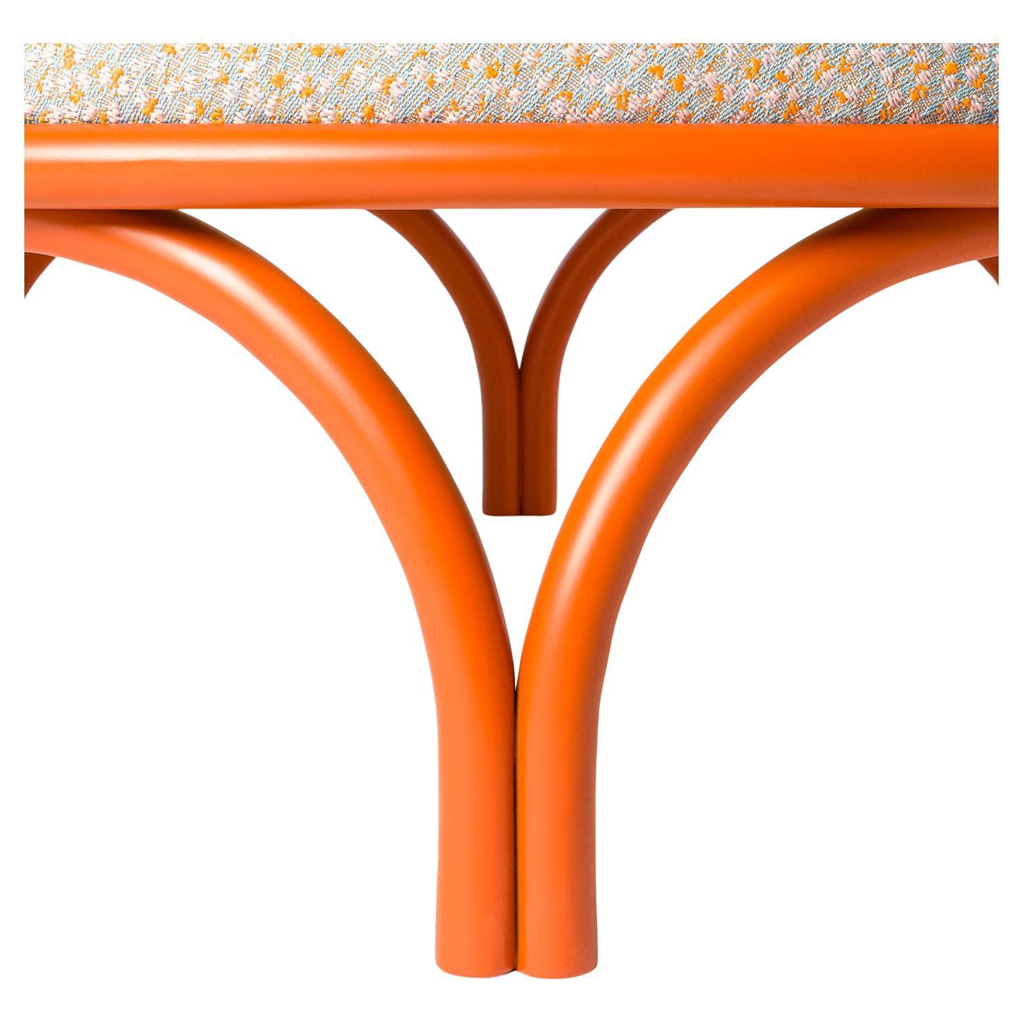 A sublime encounter of sinuous lines and dynamic movement, this exceptional round pouf showcases a playful design. Handcrafted of curved and orange-lacquered wood, it features a large and welcoming, softly-padded seat upholstered with fabric.