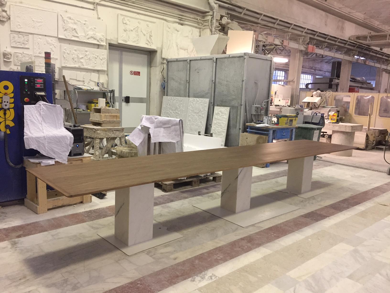 The Arcaico wood dining table is polished with a Walnut Matte finish in two pieces that are conjoined at the center. Perfect for any home or living space. Please inquire for information about other marble material choices.