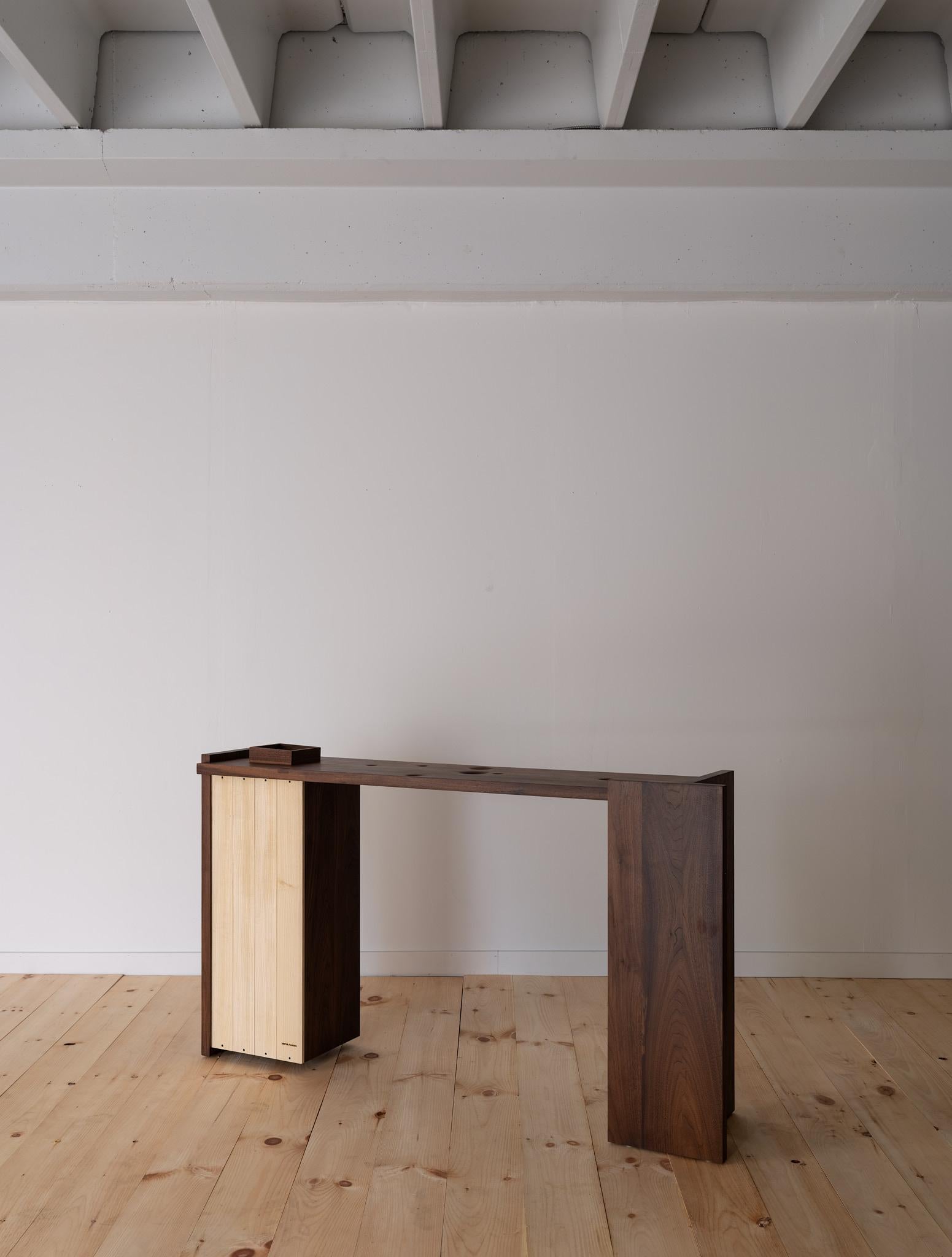 The Arcana Console balances precision and warmth. Across its solid-wood surface, a constellation of shallow dimples adds gentle texture and visual rhythm. A recessed section holds two custom inserts—a solid-wood tray for everyday items like keys or