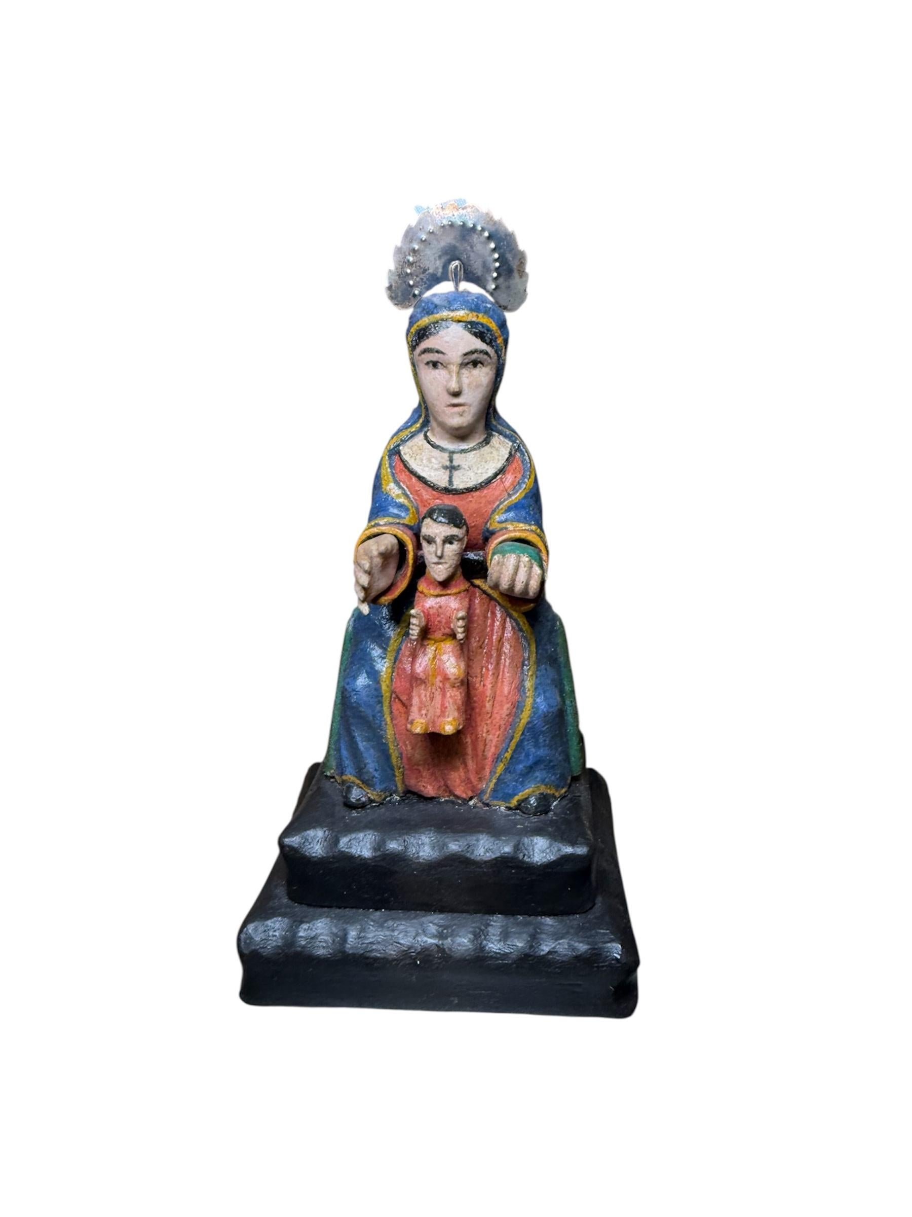 Questo è un Santo de Palo/scultura in legno intagliato a mano della Vergine di Monserrat con nicchia di Arce. Raffigura una Vergine di Monserrat dipinta a mano seduta con Gesù Bambino in grembo. La sua testa è ornata da una corona di metallo