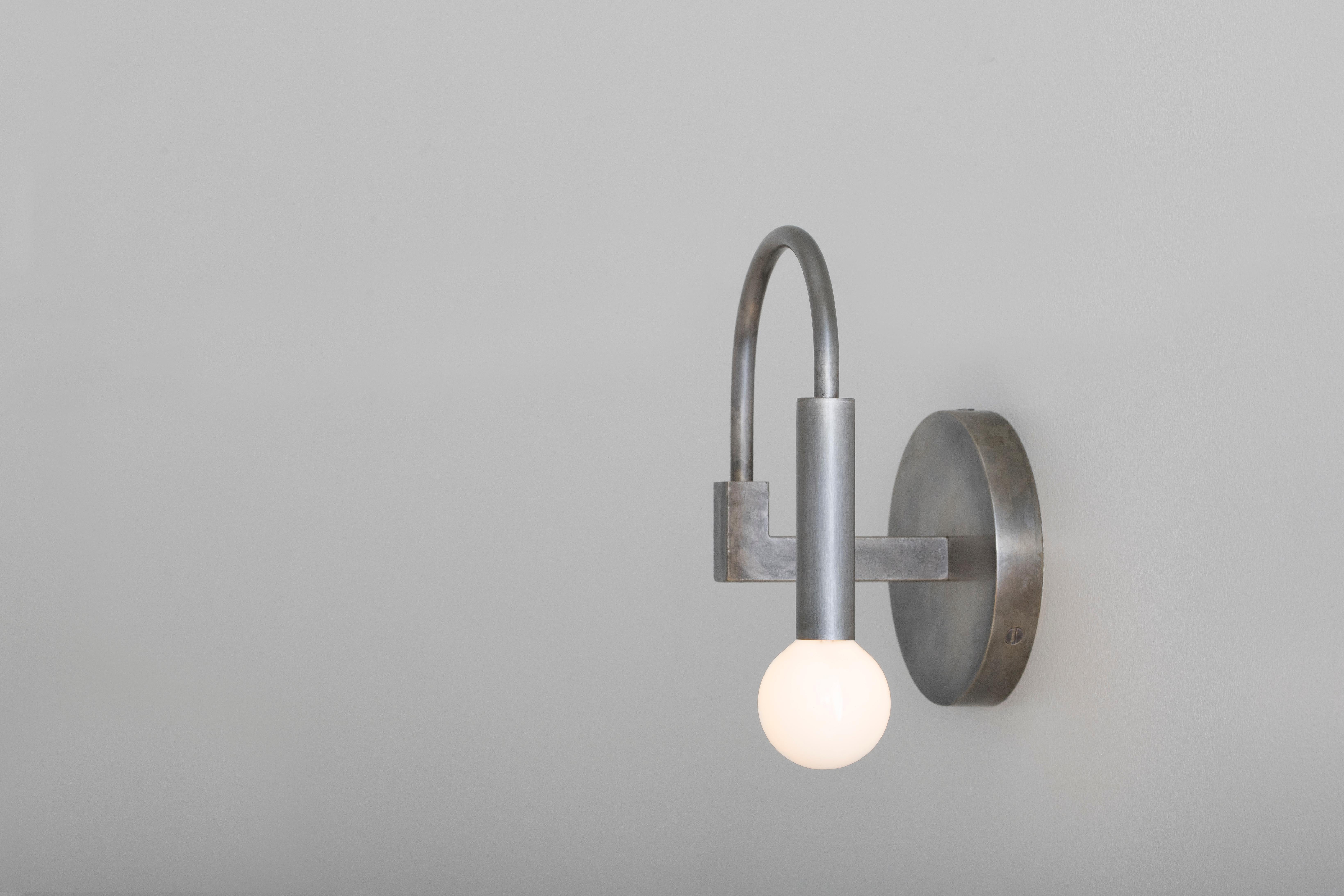 Arch 
Arch draws on the elemental forms of Roman architecture to create a playful yet timeless sconce, blurring the line between traditional and contemporary design. 

Details
This listing is for one arch wall sconce in Vintage Silver with satin