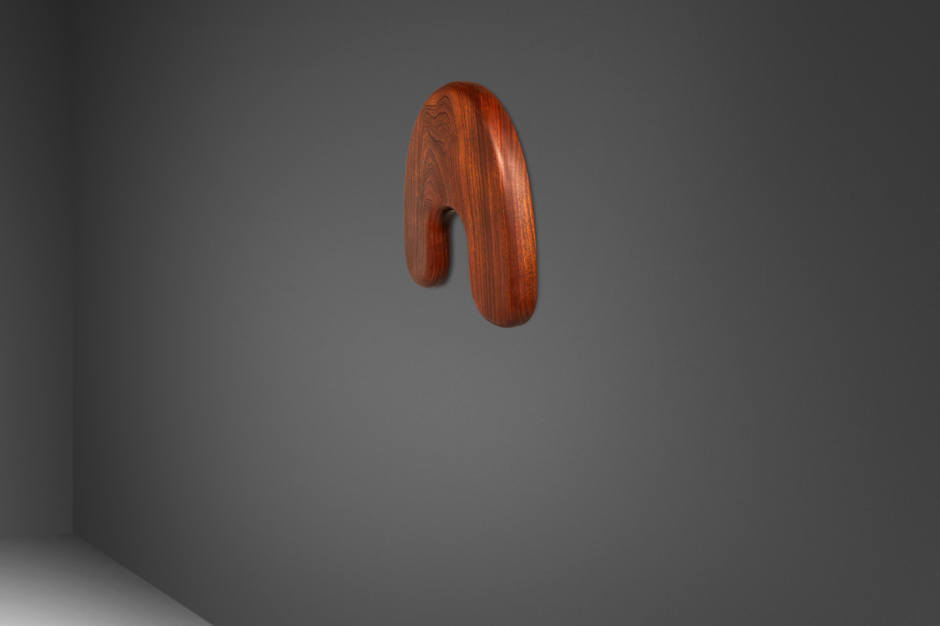  Introduce your home to a touch of organic elegance with this one-of-a-kind hanging wall art designed and carved by Mark LeBlanc for Leblanc Studios. Masterfully crafted from rare and intentionally sourced African Sapele Mahogany, this hanging piece