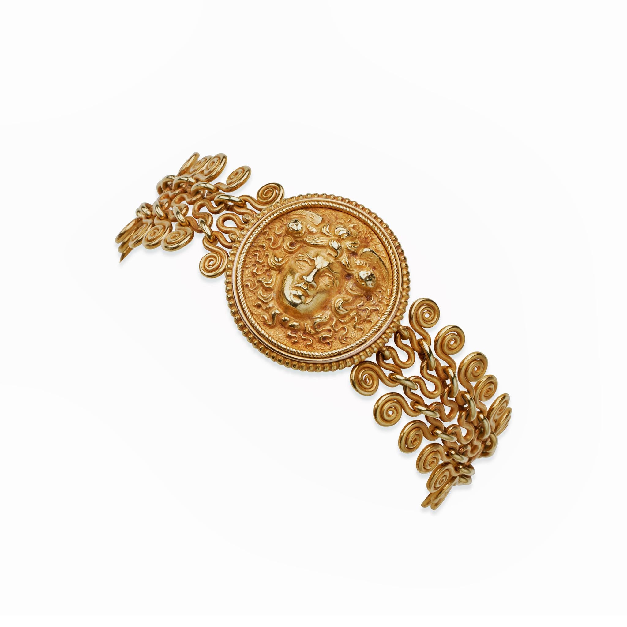 Created circa 1870, this 22K gold bracelet belongs to the archaeological revival style of jewelry. It is designed as spiraling gold wirework links after prehistoric bronze models joined by interlocking meander motif loops, centering a high relief