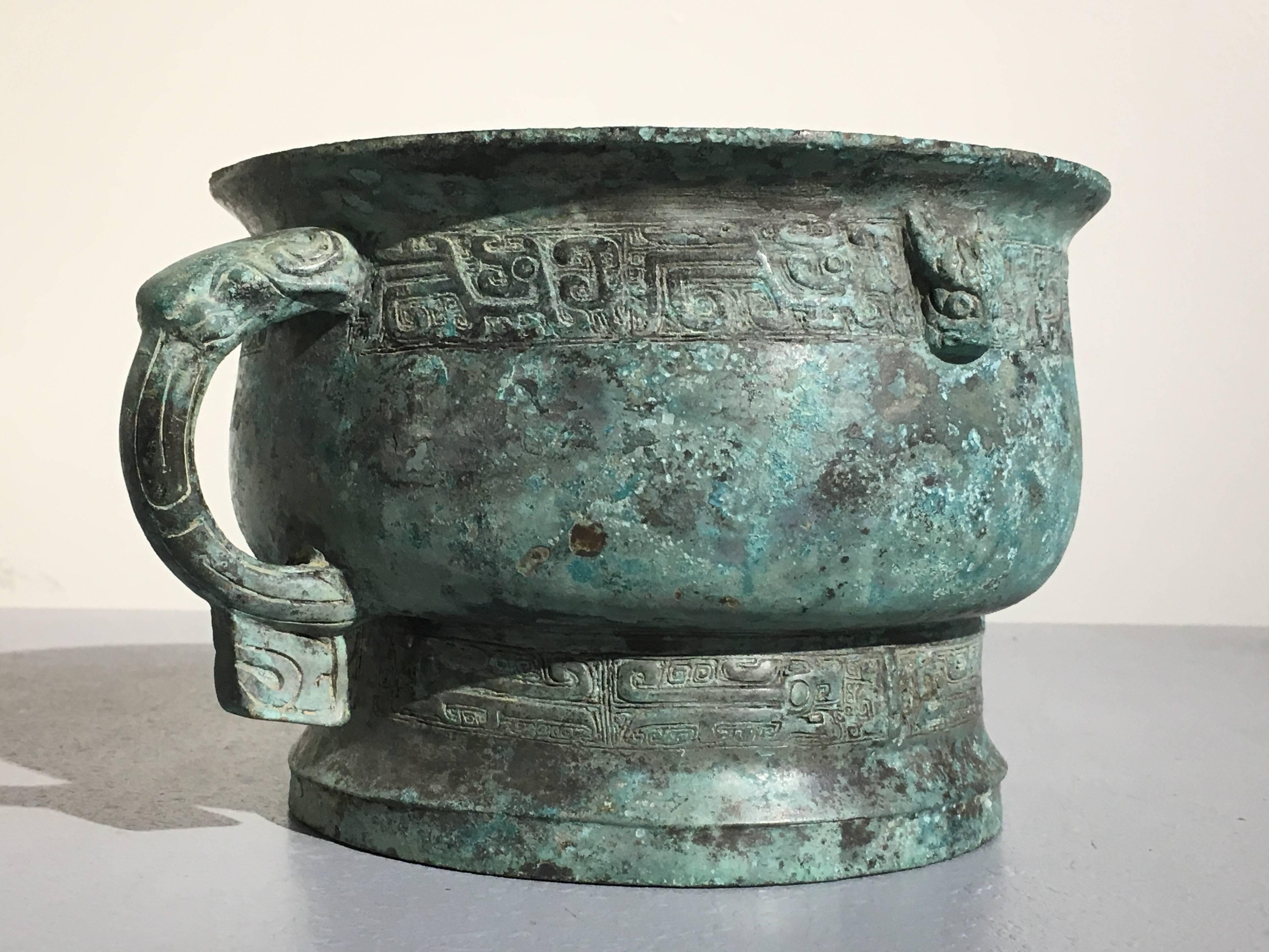 A stunning and rare Chinese archaic bronze gui, a type of ritual bronze vessel used to hold grain, either for feasting, or for making offerings to the ancestors, late Shang to early Western Zhou Dynasty, circa 11th century BCE. 

The gui cast with a