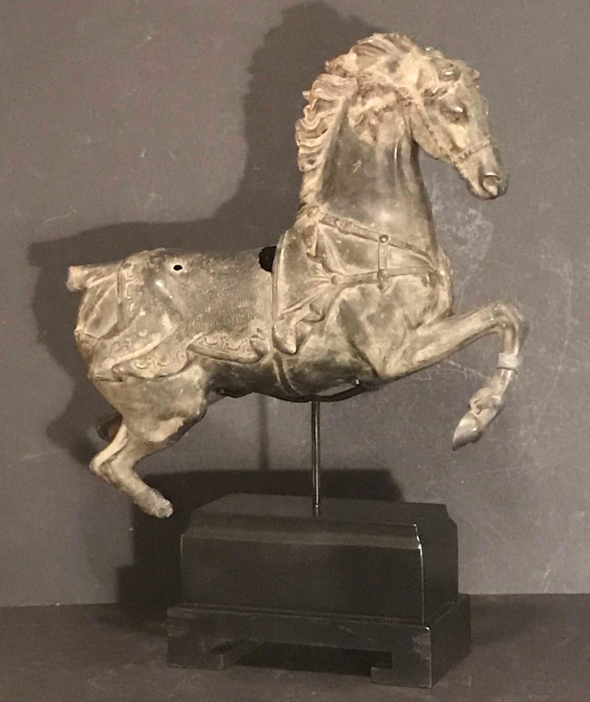 This beautiful Chinese Equine statue is of great workmanship. It is made of bronzed metal with an excellent patina. The horse sculpture is modeled in perfect style, with intricate details and it shows strength in its forward movements. Age has left