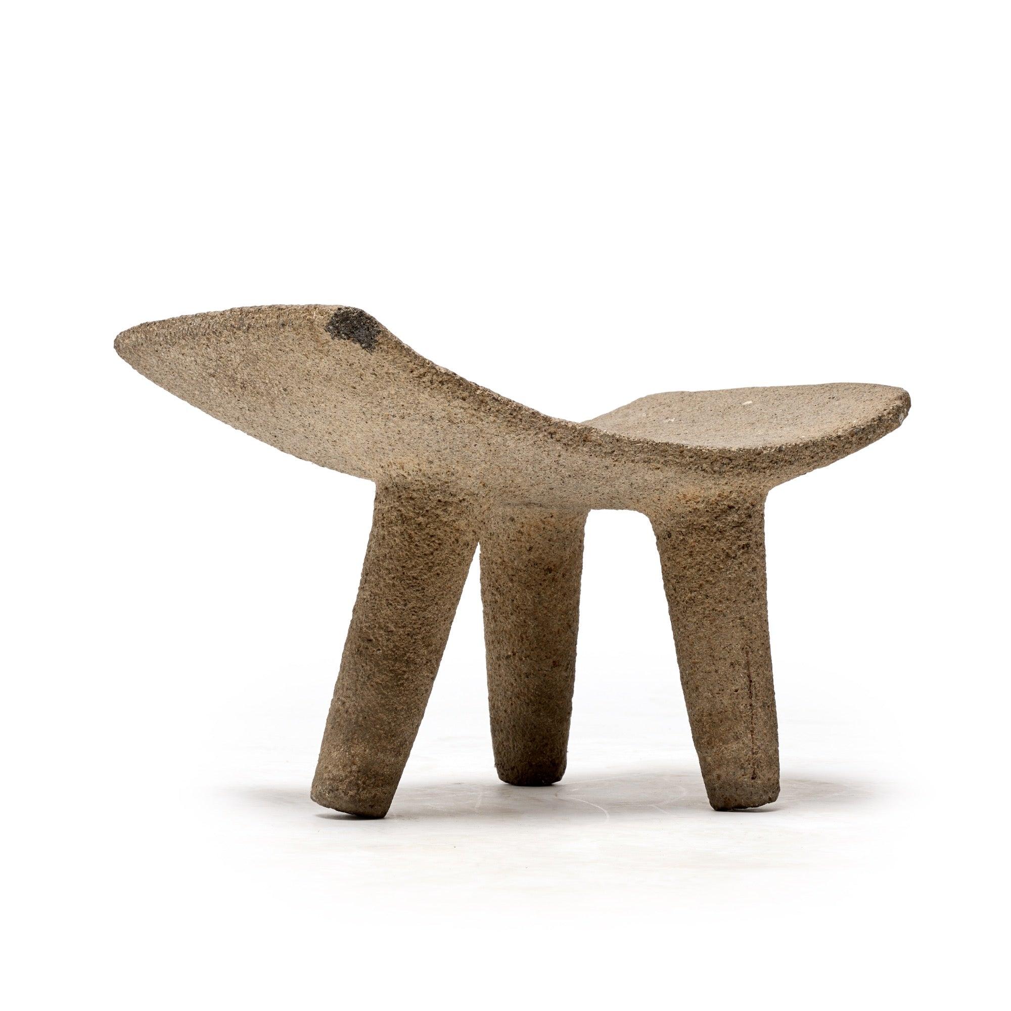 D'origine inconnue, un banc sculpté en pierre massive avec un dossier bas et trois pieds asymétriques. Un trou dans le siège a été fait pour le drainage. Il peut être vieux de plusieurs centaines d'années ou avoir été fabriqué au XXe siècle. Il ne
