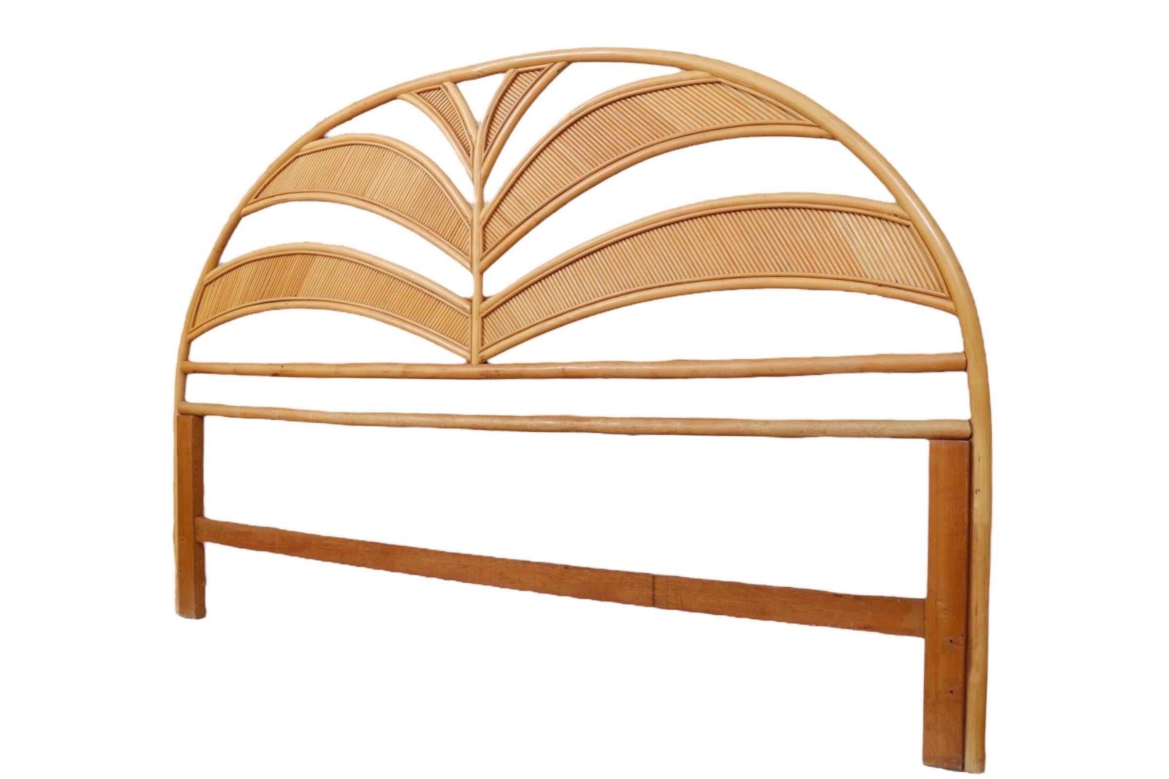 A king size arched bentwood bamboo headboard. Decorated with waves of bamboo with split rattan panels reminiscent of waves or palm fronds.
