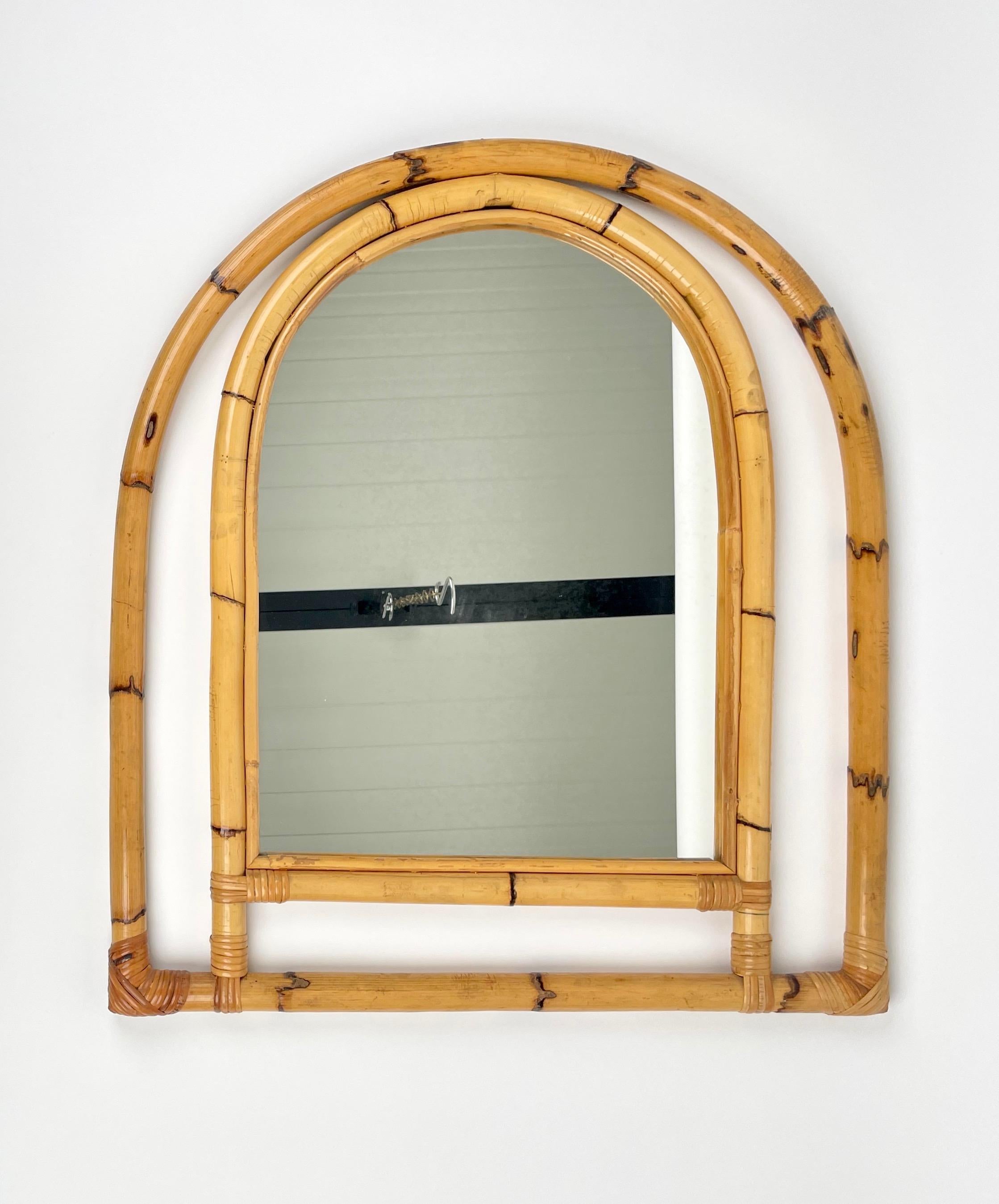 Arched wall mirror framed with bamboo and rattan.

Made in Italy in the 1970s.