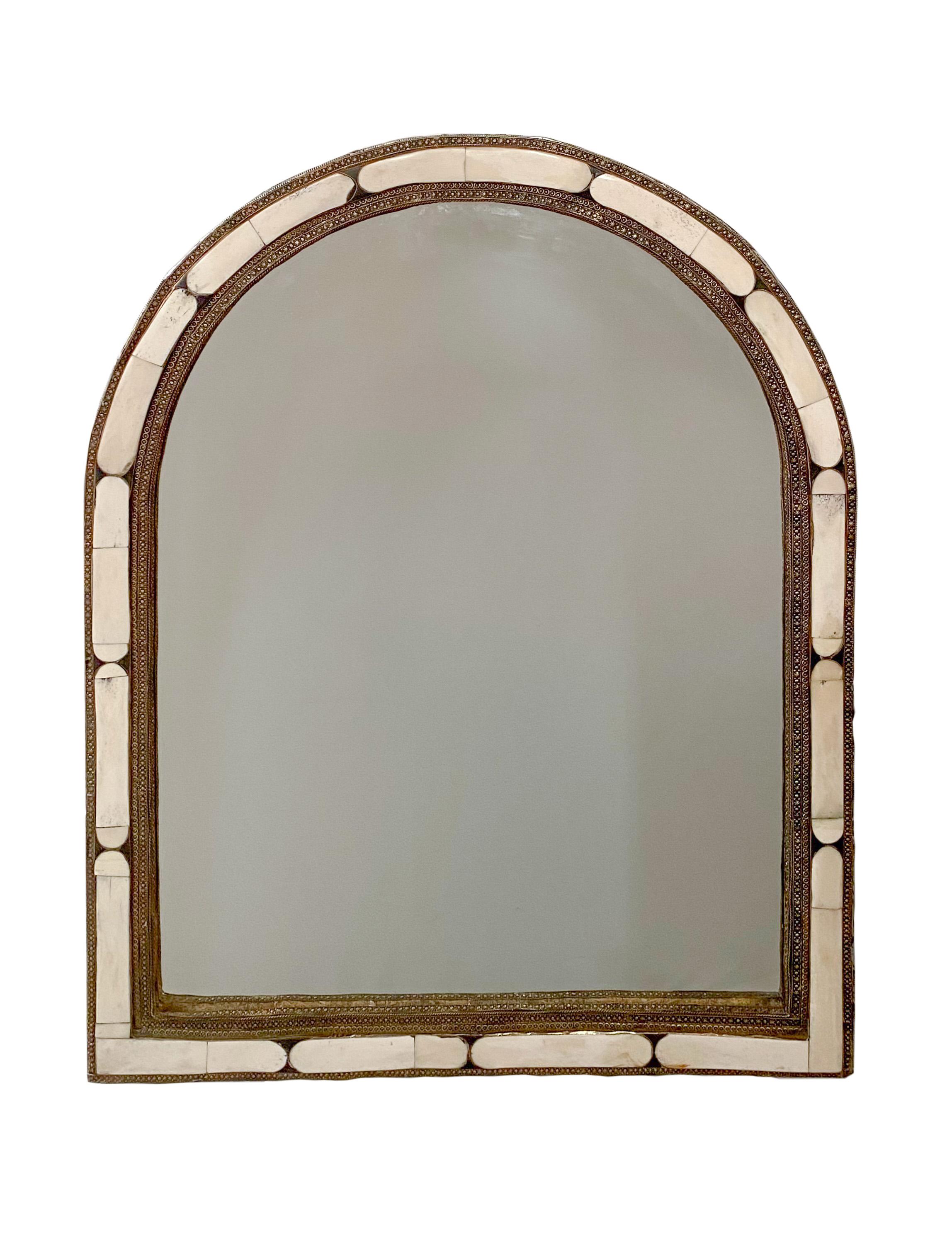 Arched Hollywood Regency White Camel Bone Mirror, a Pair A pair of arched white camel bone mirrors. With white camel bones inlaid into an elegant brass frame, this pair of handmade Hollywood Regency mirrors will complement any room and interior