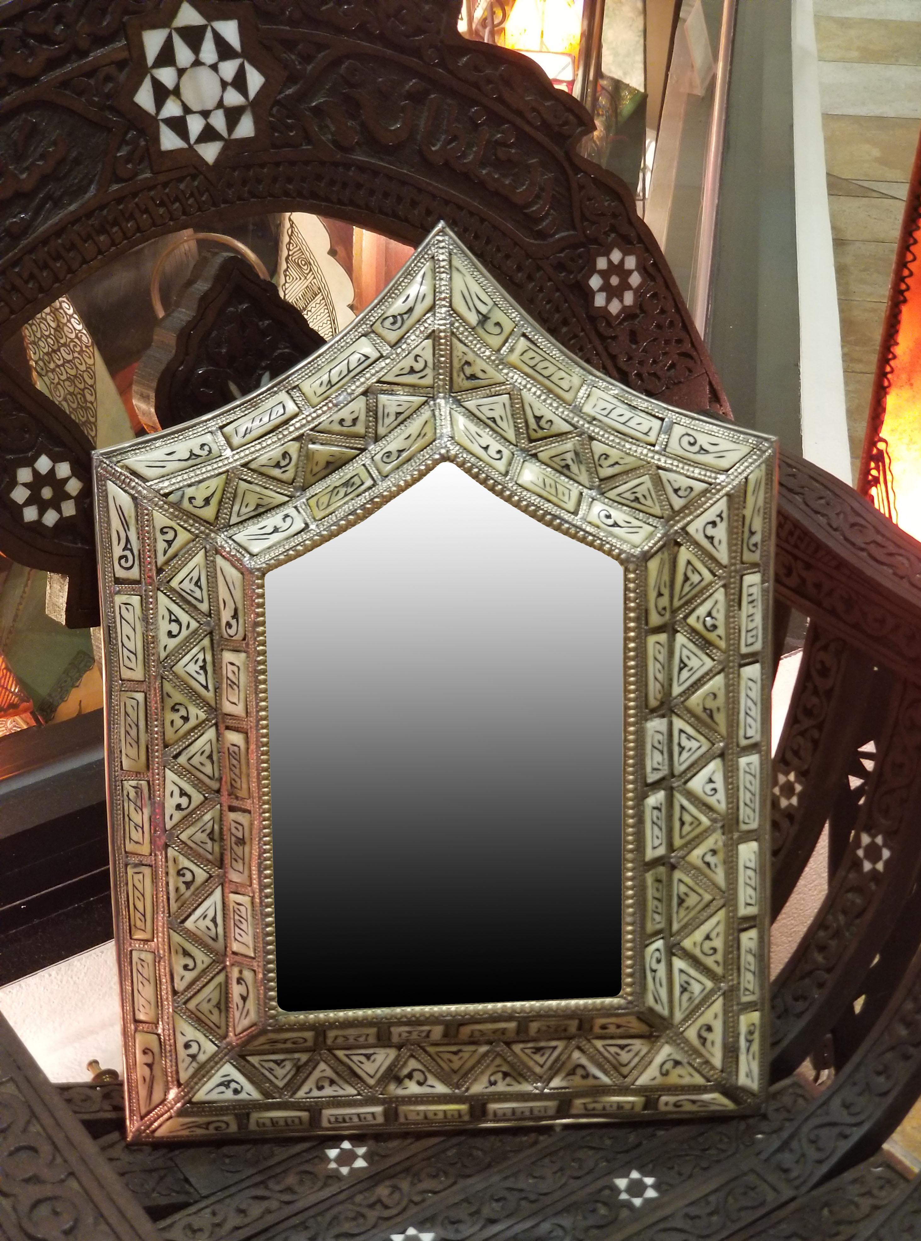 Medium size metal inlaid and camel bone Moroccan mirror. Made in the city of Marrakech. Arched shape measuring approximately 19