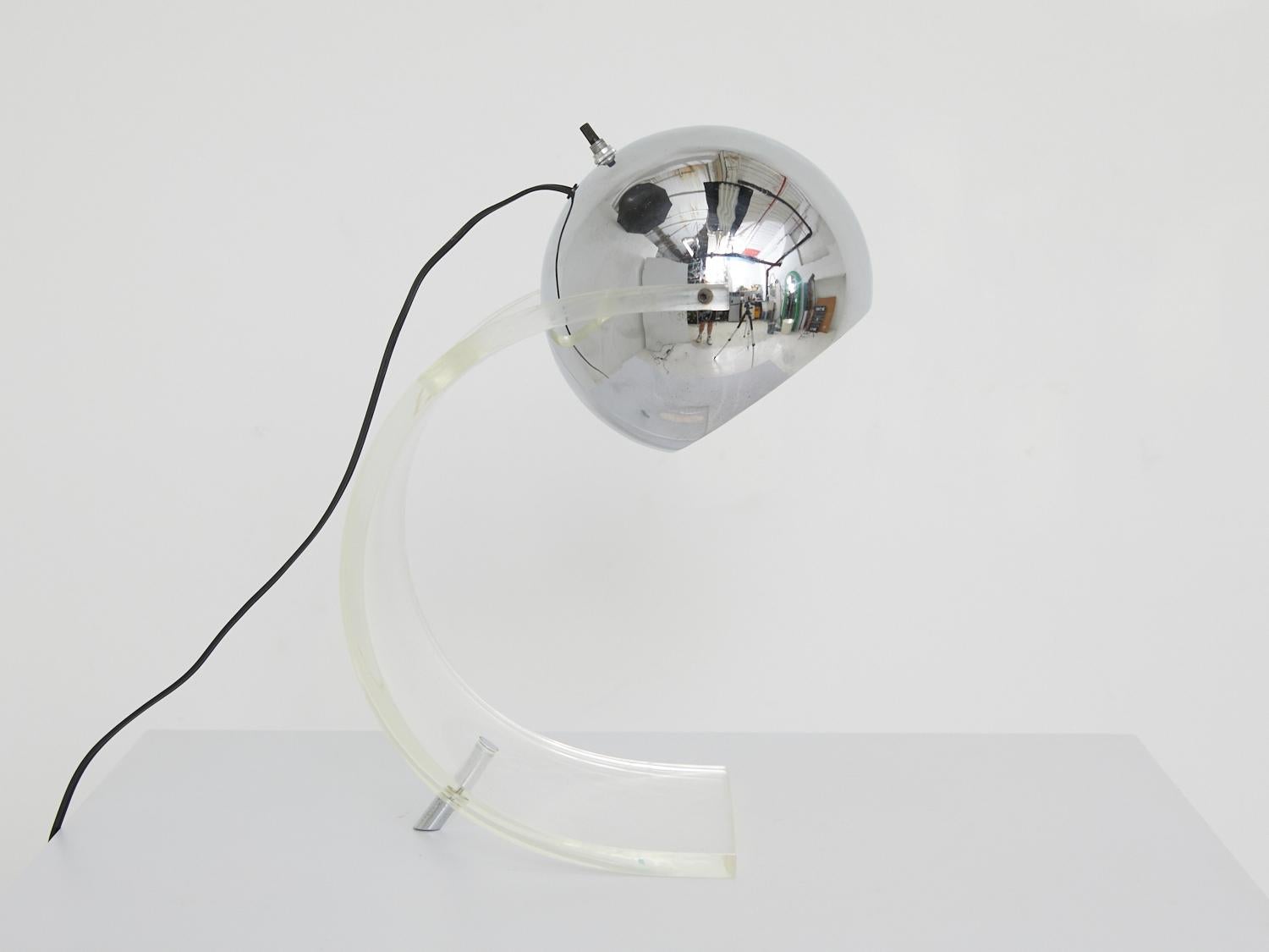 Add a dash of whimsy to your tabletop with this lamp that knows how to have fun. Its curvy silhouette and glossy chrome details create a lighthearted vibe, while the Lucite body adds a touch of modern cool. It's the ideal companion for those who