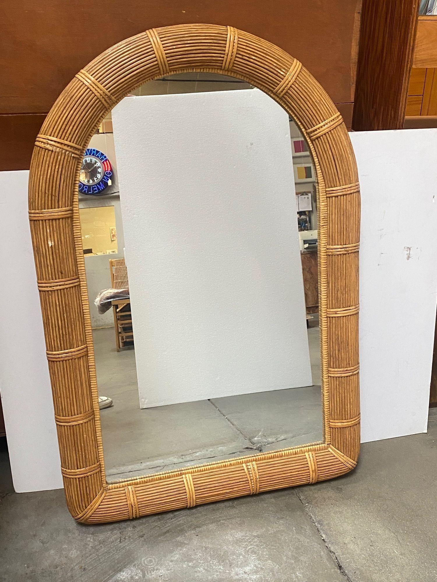 Mid-Century Modern Bohemian chic arch-shaped handwoven pencil reed and wicker wall mirror. Bent pencil reeds are firmly lined on a sturdy wooden backing.